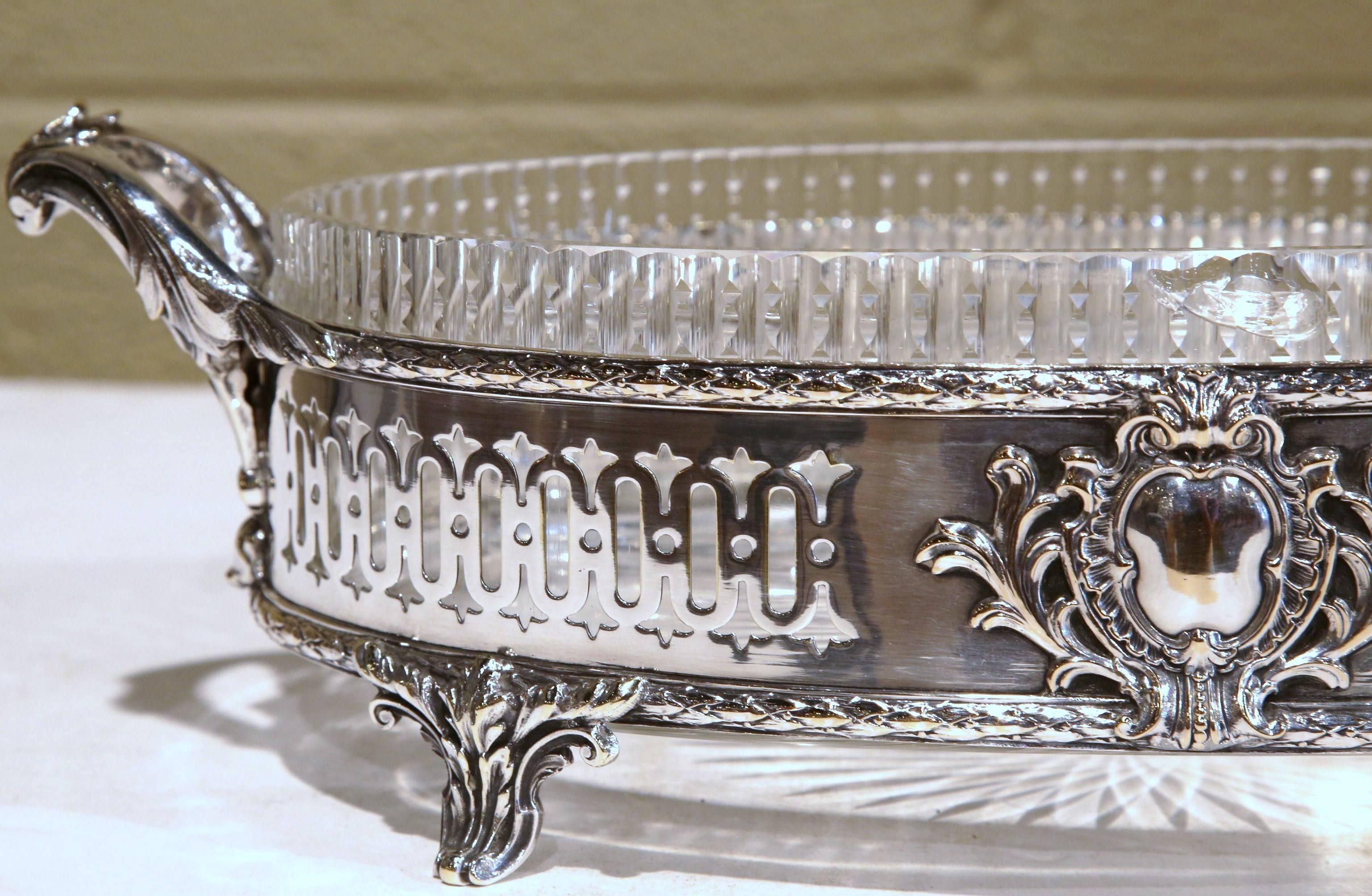 Decorate a dining room table with this elegant centerpiece. Created in France, circa 1860, the antique oval planter sits on four small curled feet, with ornate handles at each end, and features repousse decor including a center foliage medallion on