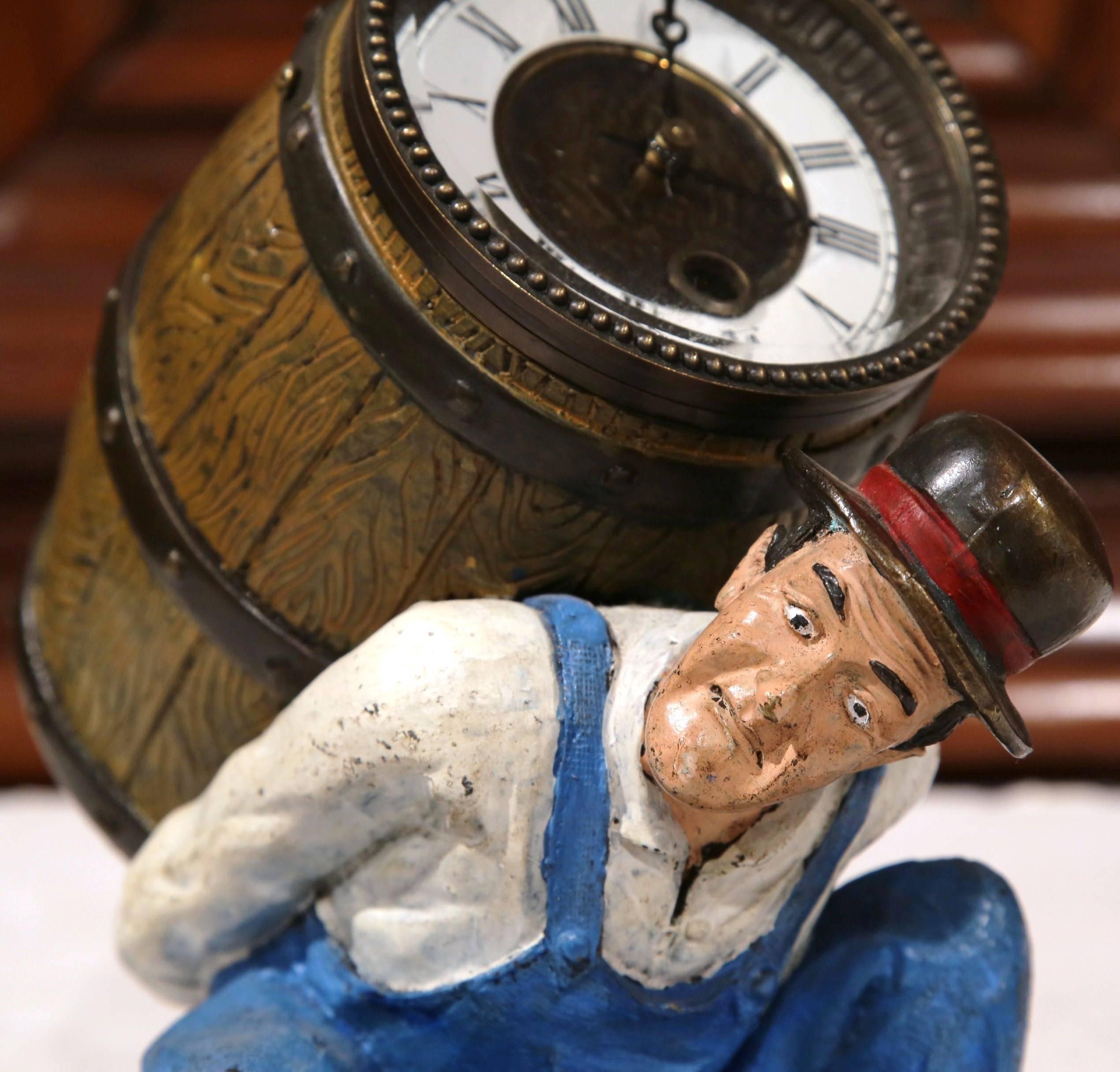 Decorate a desk or bookshelf with this interesting bronze and painted table clock. Crafted, circa 1900, the sculpture depicts an expressive wine maker holding a barrel with a clock inside. The clock mechanism is in excellent working order and has a