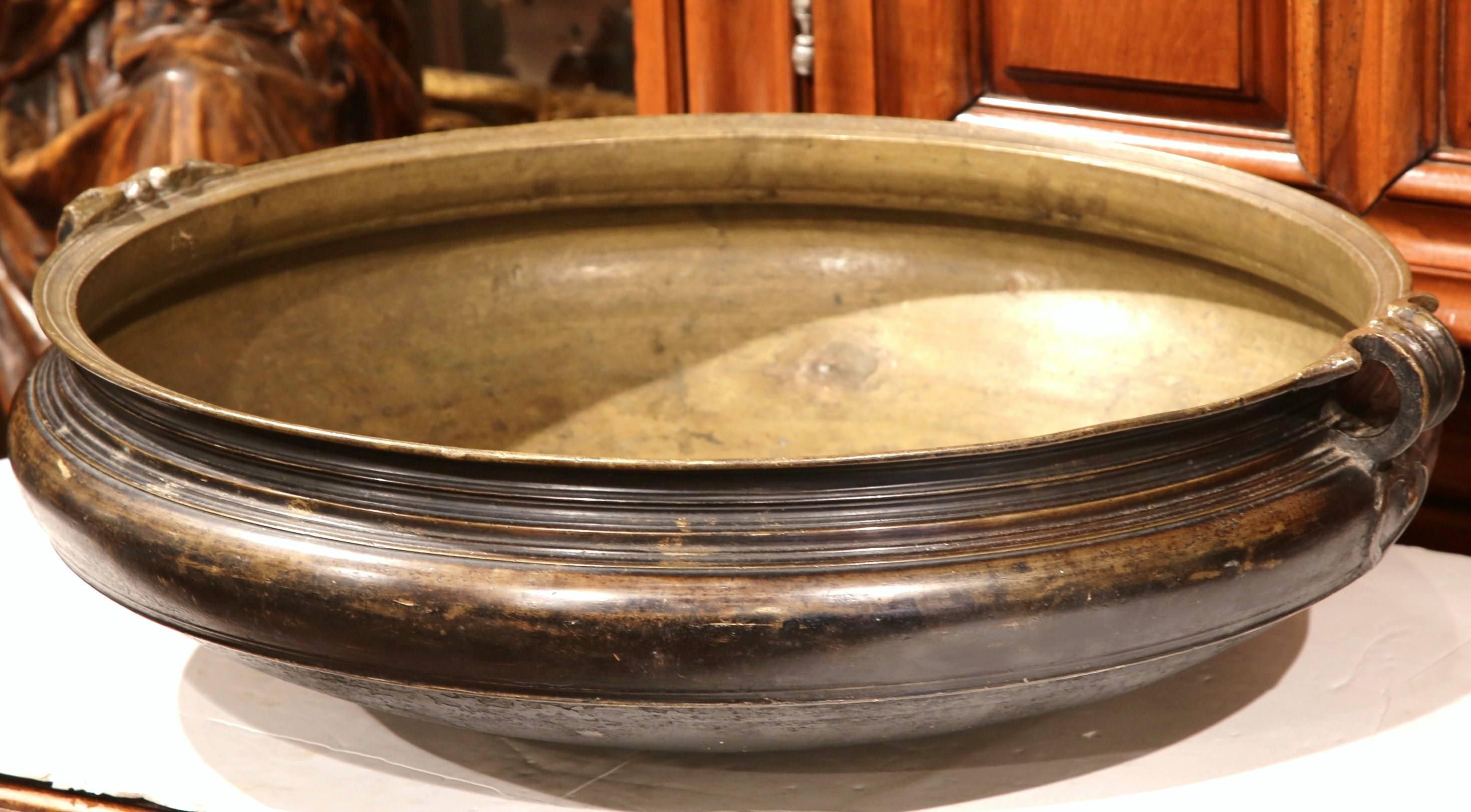 Decorate a table or counter top with this elegant bronze cooking dish from Southern India, circa 1860. The antique Urli has a neoclassical shape with wide mouth, short height and handles on both sides, and was a traditional container used for