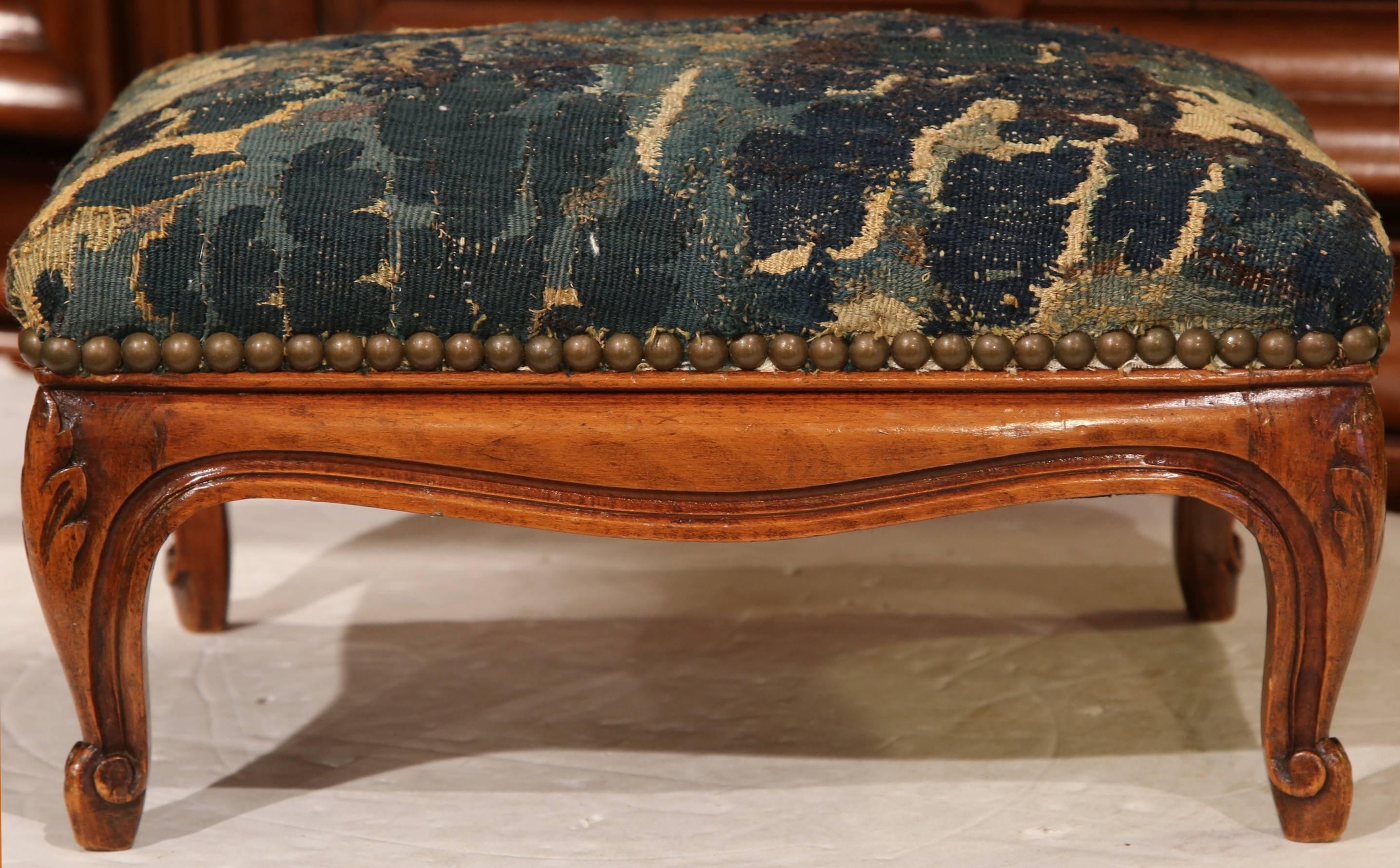 This elegant, antique stool from France, circa 1870, would make a wonderful addition to any home regardless of style. Reupholstered with 18th century Aubusson tapestry and embellished by patinated brass nail heads, the fruit wood stool flaunts a