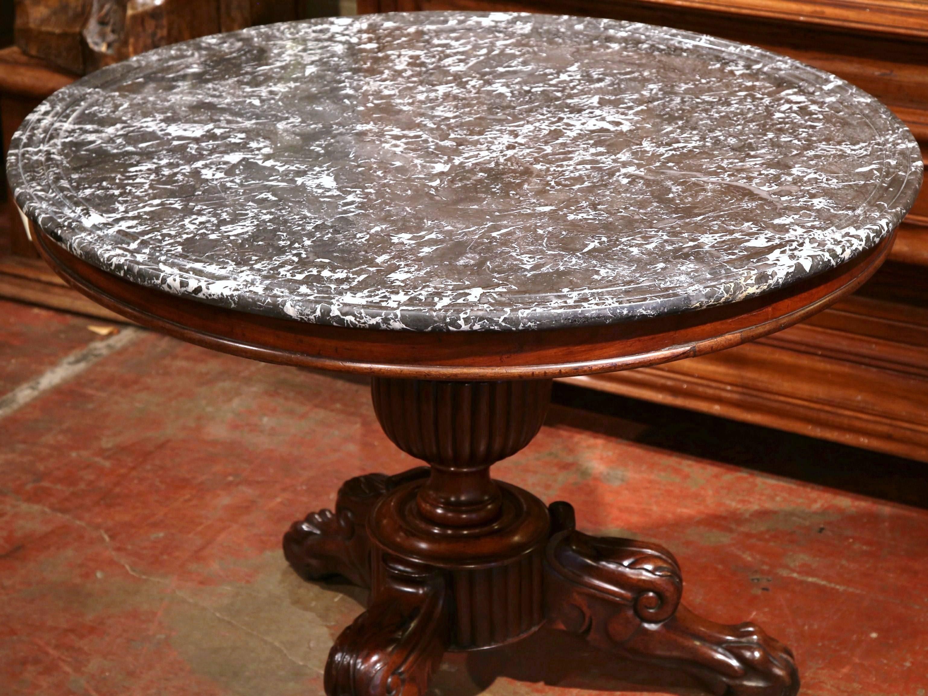 Complete your entry or breakfast nook with this beautifully carved, round pedestal table. Crafted in France, circa 1870, this table has a gray marble top supported by a large, reeded hand carved urn column. The table rests on three carved legs with