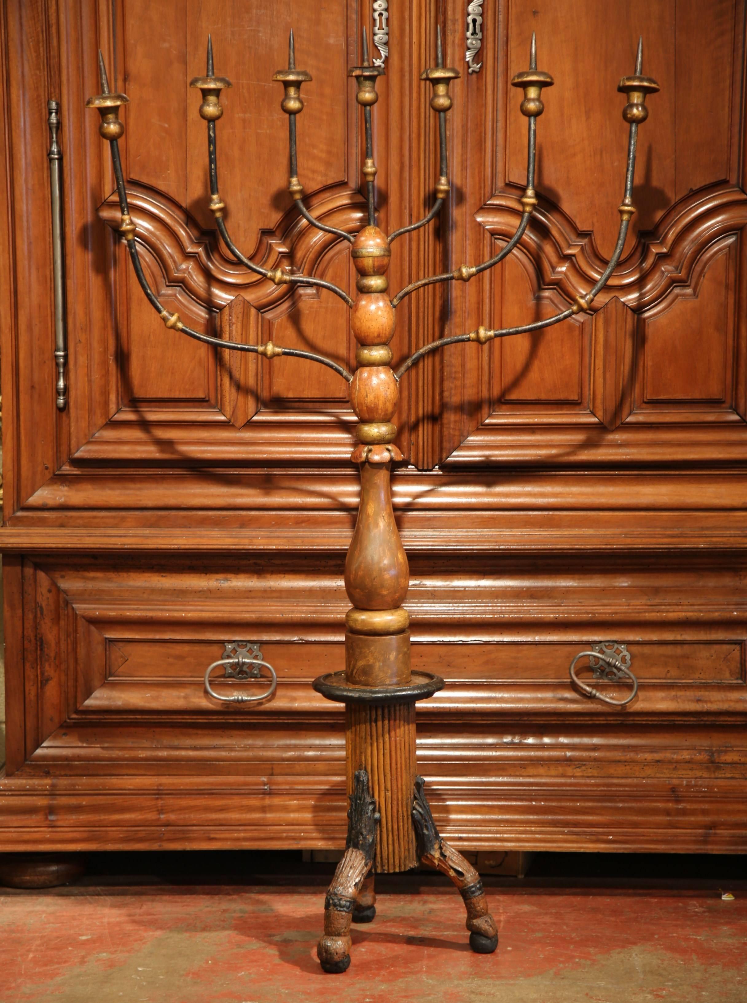 This elegant, antique candleholder was created in Italy, circa 1680. The tall freestanding candelabra has not been wired but features seven wrought iron curved arms with wood bobeches to hold candles for a dramatic effect. The turned base sits on