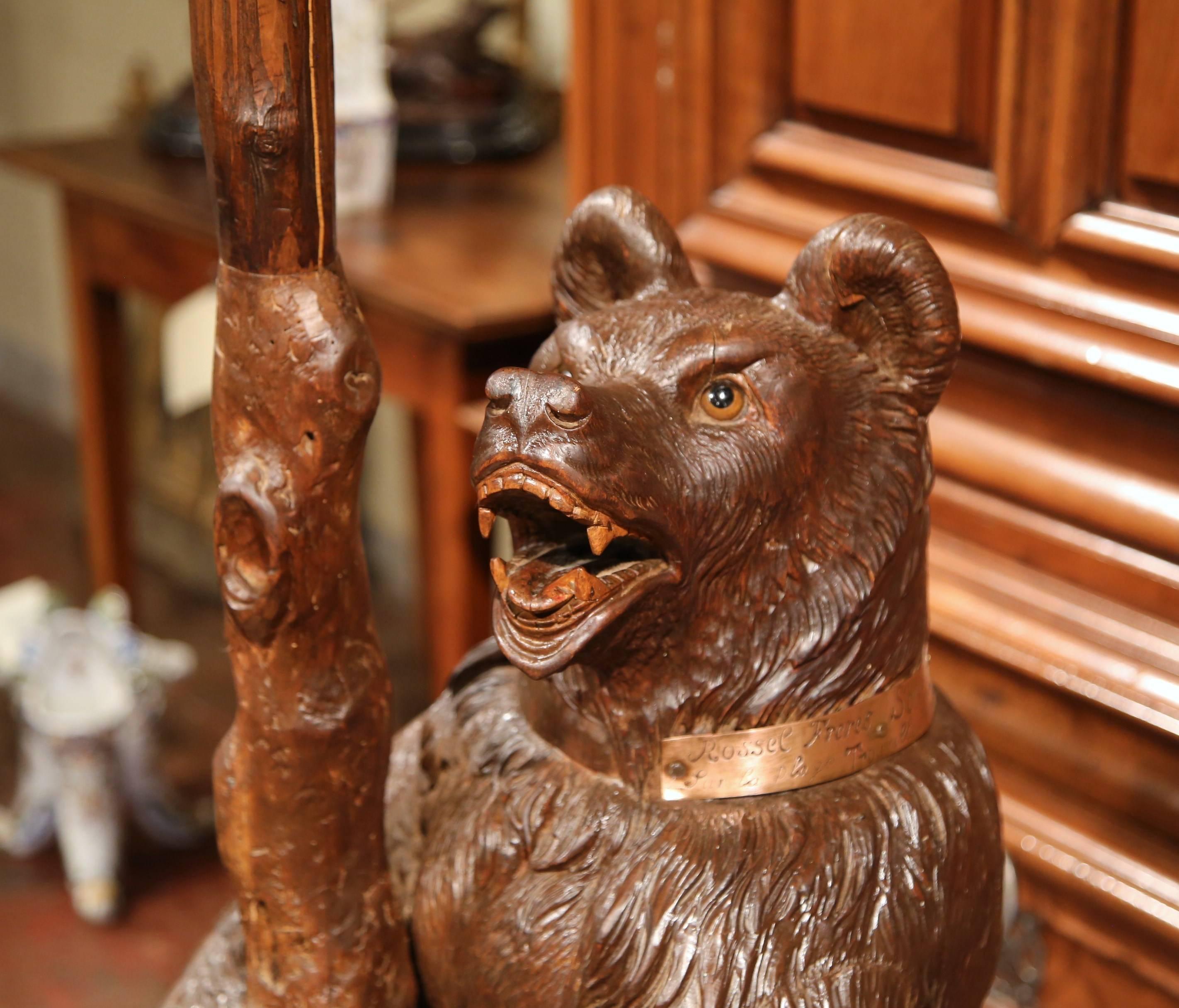 This beautiful, antique walnut bear umbrella stand was crafted in Switzerland, circa 1860. The animal sculpture features a standing bear embellished with original glass eyes, and a slightly stained mouth and tongue. The fruitwood mammal has a copper