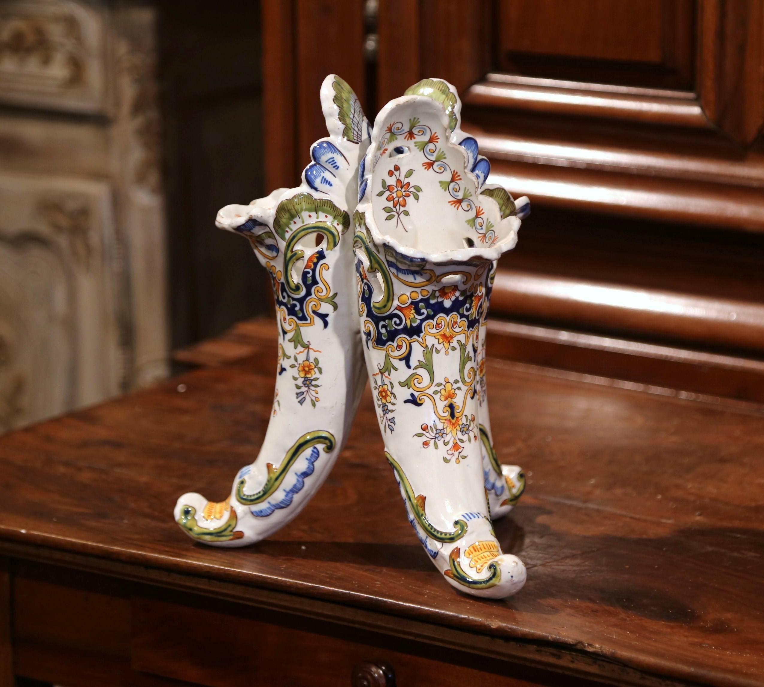 Place this interesting antique ceramic vase on a shelf or entry commode, crafted in Normandy, France, circa 1900, the Classic vase shaped as cornucopia, features hand painted floral decorations in the blue, yellow, green palette. The bouquetiere