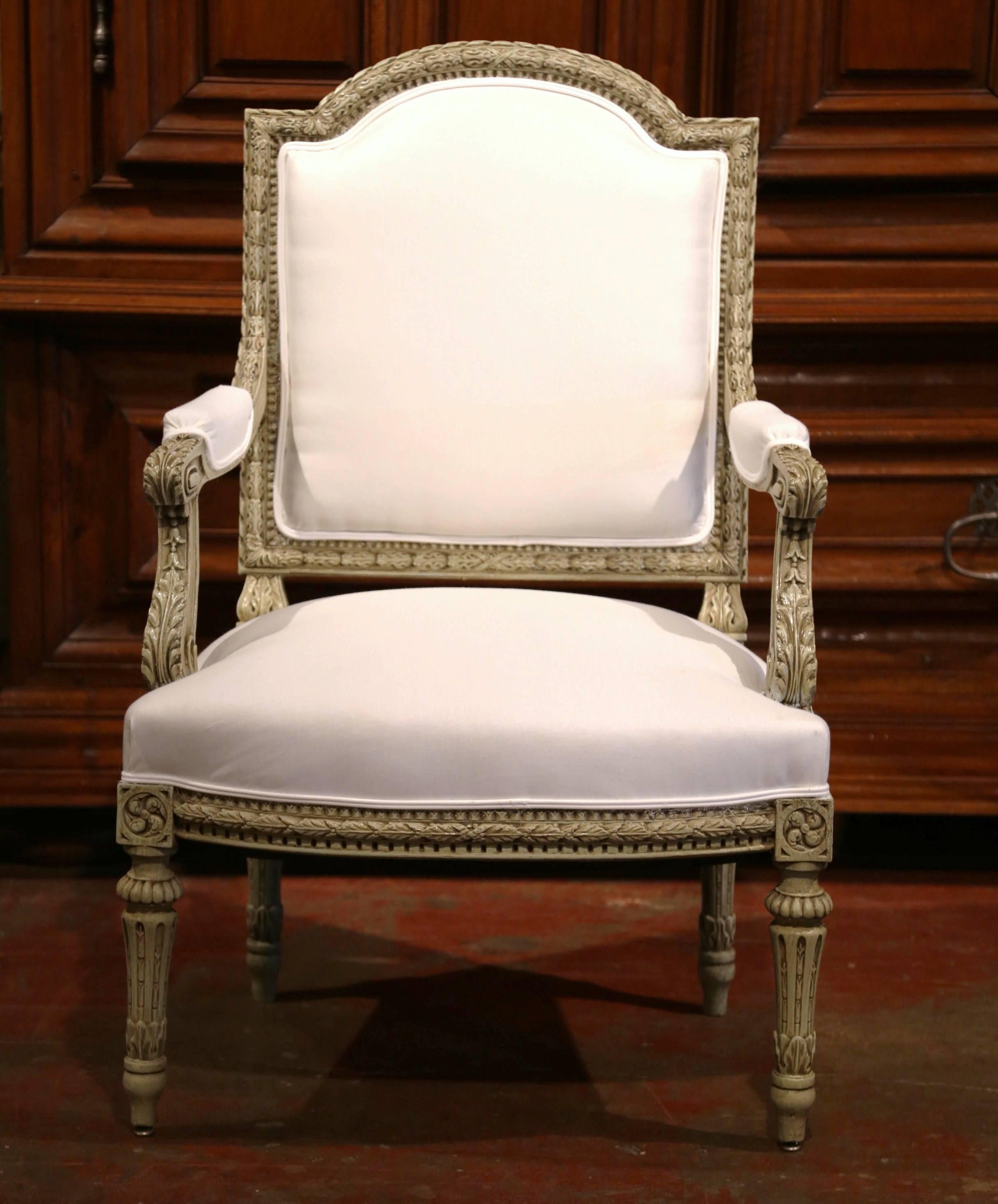 Elegant antique painted armchair from France; crafted circa 1880, the desk chair features intricate carving, tapered legs, armrests with acanthus leaves, and it has been reupholstered with white muslin. Excellent condition with rich patinated grey