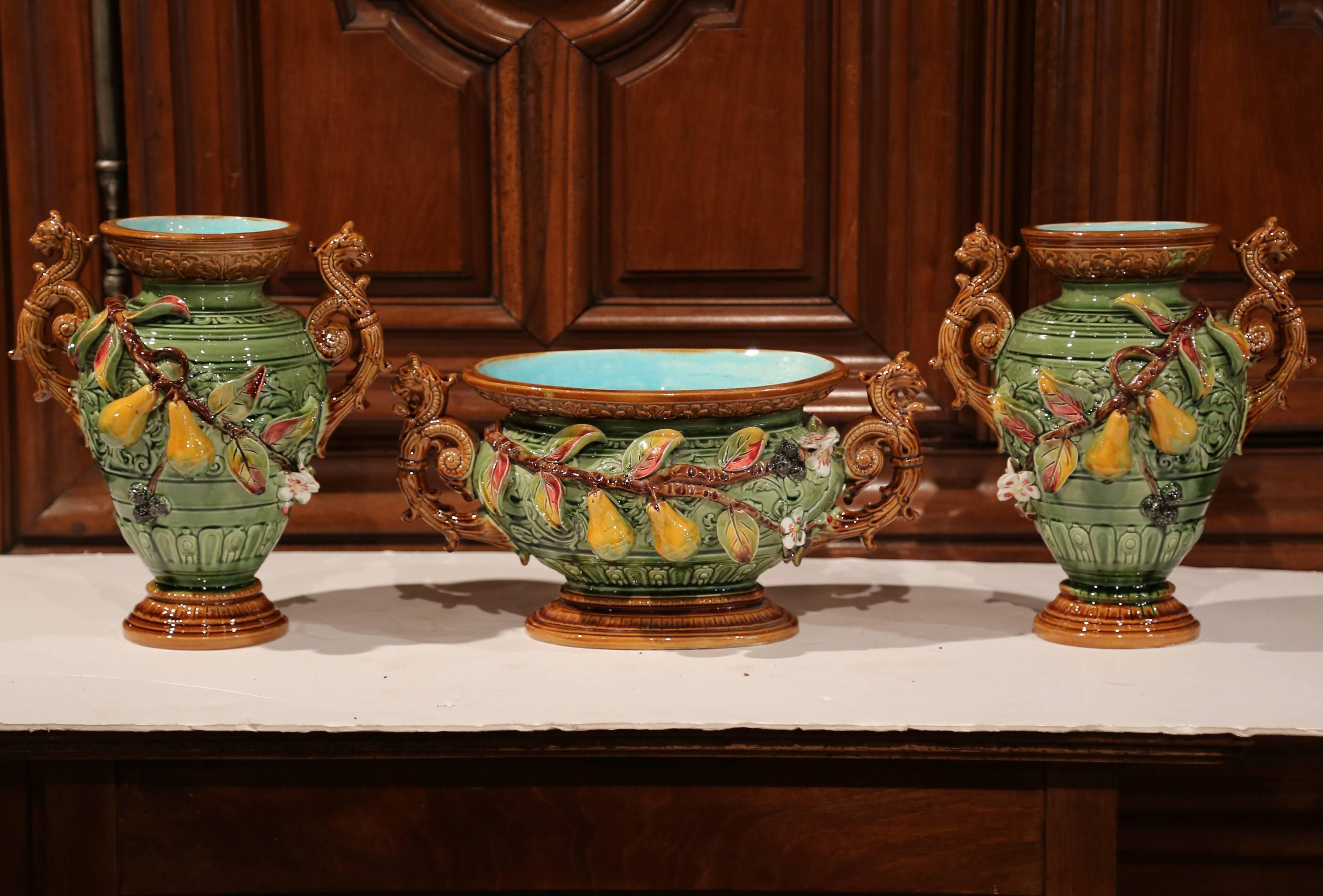 This beautiful three-piece set has two Majolica vases and a matching planter; crafted in Southern France, circa 1880, this composition is an impressive, Classic example of barbotine artistry. The sculptural, ceramic pieces features a nature-inspired