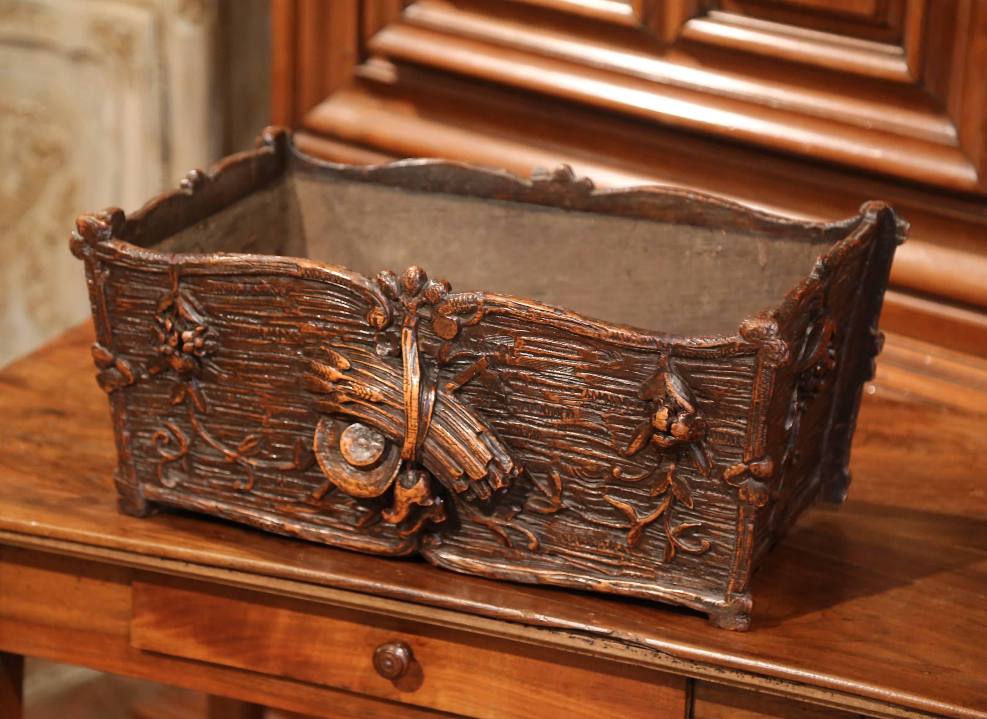 This elegant antique jardiniere carved as a log was crafted in France, circa 1870. The detailed, rectangular planter features fine hand carvings that include wheat, flowers, and even a pair of clogs and a farmer’s hat. The piece is in excellent