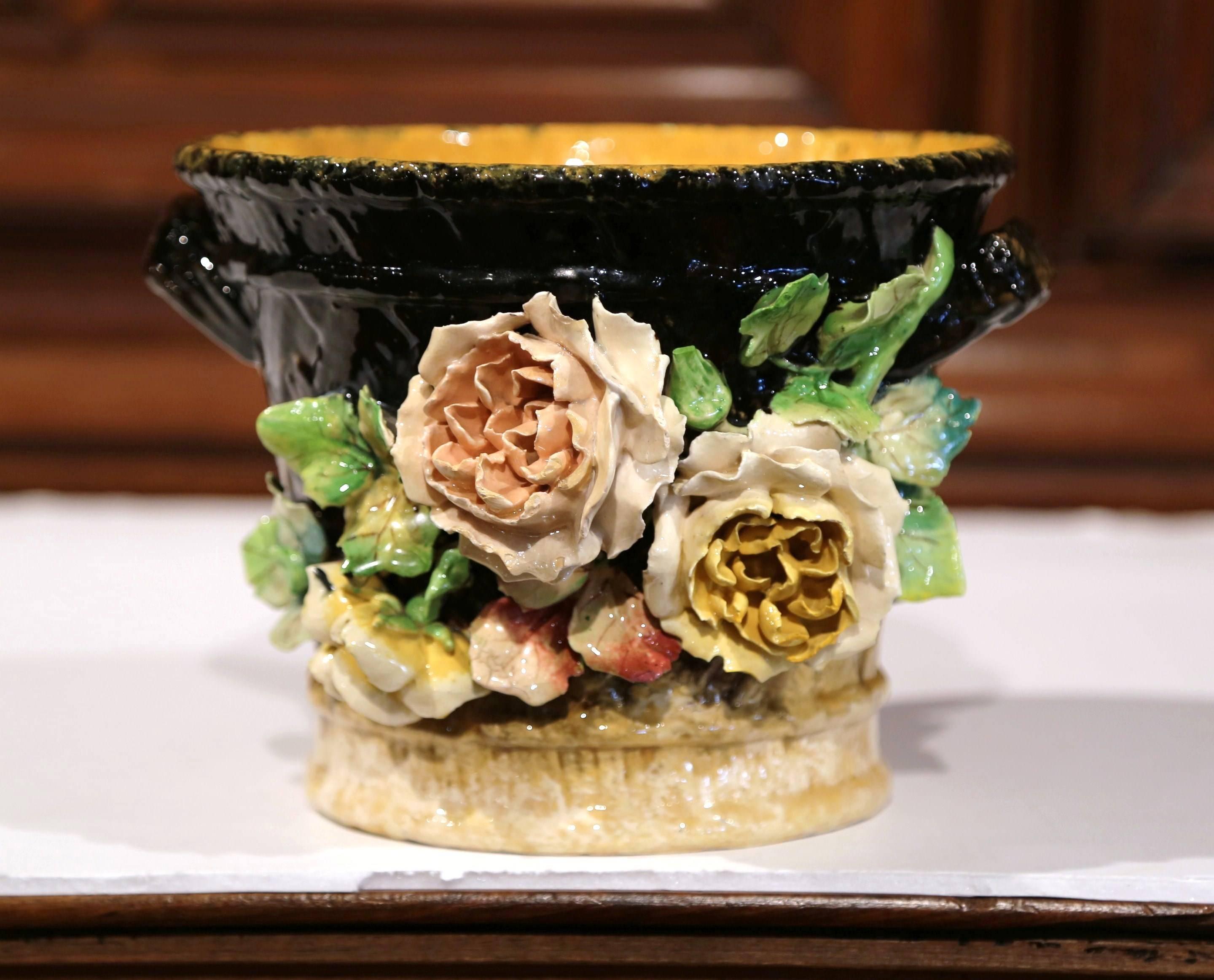 This beautiful, hand-painted majolica planter was sculpted in Montigny sur Loing, France, circa 1870. This colorful brown and yellow cache pot has a traditional, textured weave design and is embellished with large, high relief roses and flowers in a