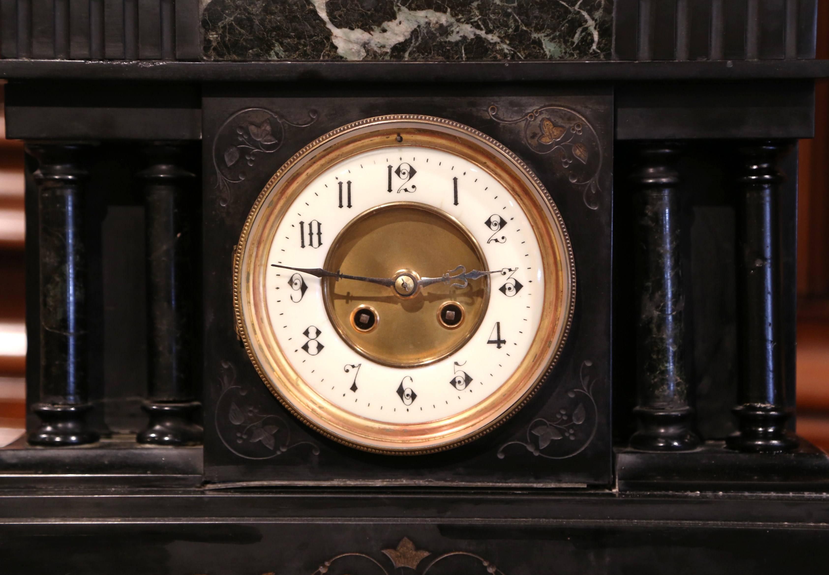 Placed this elegant, antique Napoleon III clock on a mantel. Carved in Paris, circa 1880, the time keeper is made of a carved black and green marble with inlay marquetry decor on the shaped and decorative pediment, and on the base. It is further