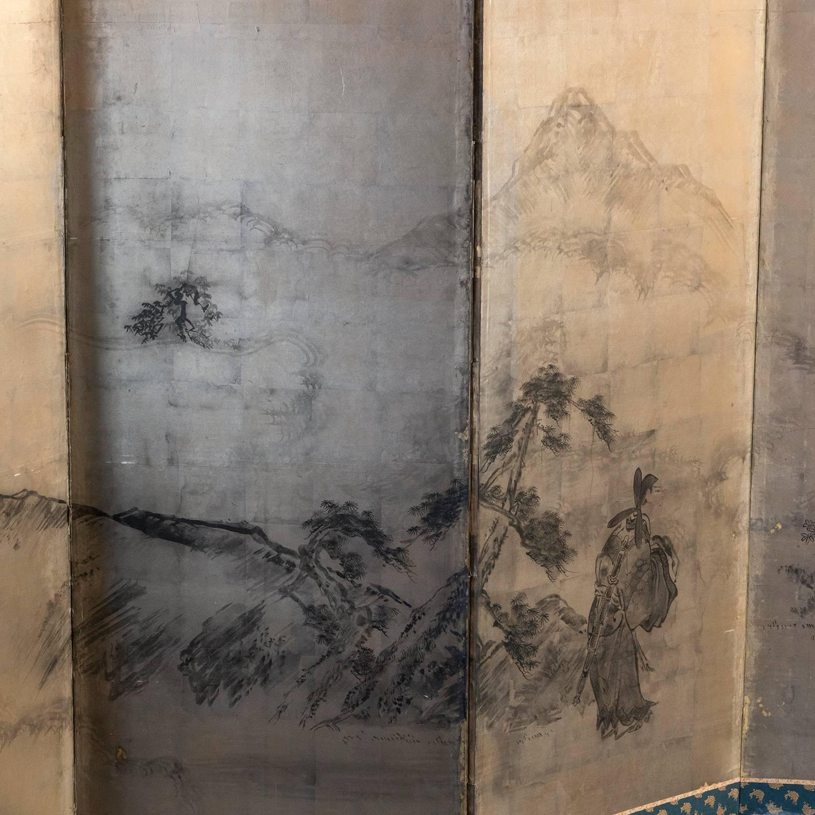 Japanese screen, ink landscape and figurative ink painting over gold leaf, silk brocade border, laquered wood frame and brass details, the back side have several rips on the paper.