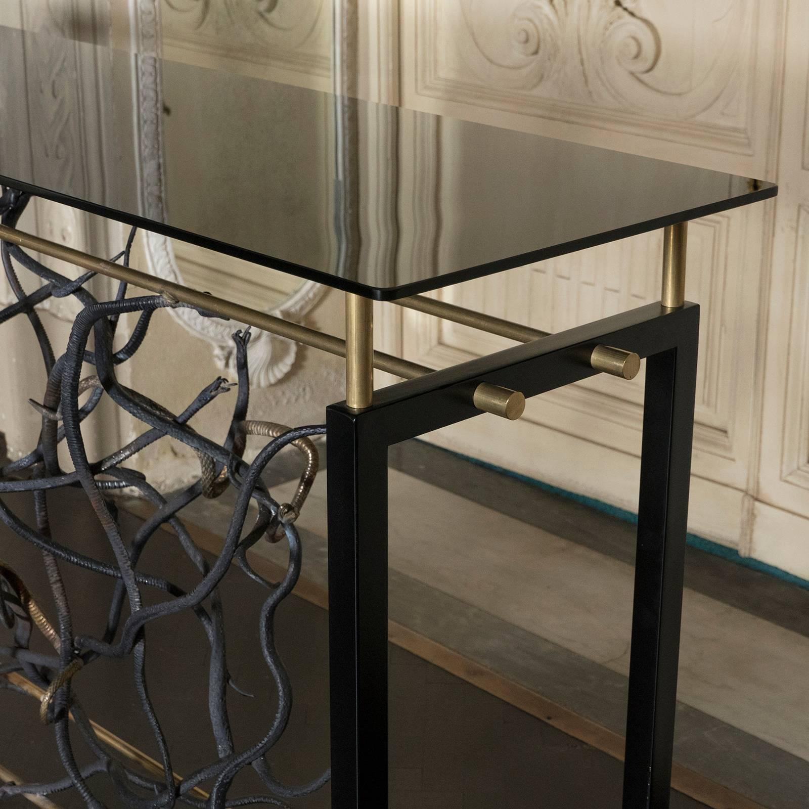 Black steel and brass console, decorative steel and brass elements, black tempered glass top.