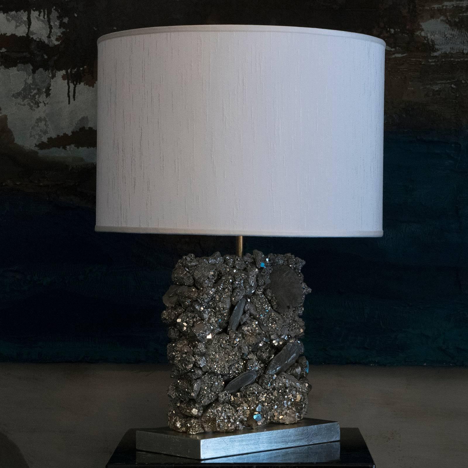 Decorative table lamp realized with Pyrite stones, wood covered with silver leaf base, brass details, silk shantung lampshade measure cm 45 x H 30.
  