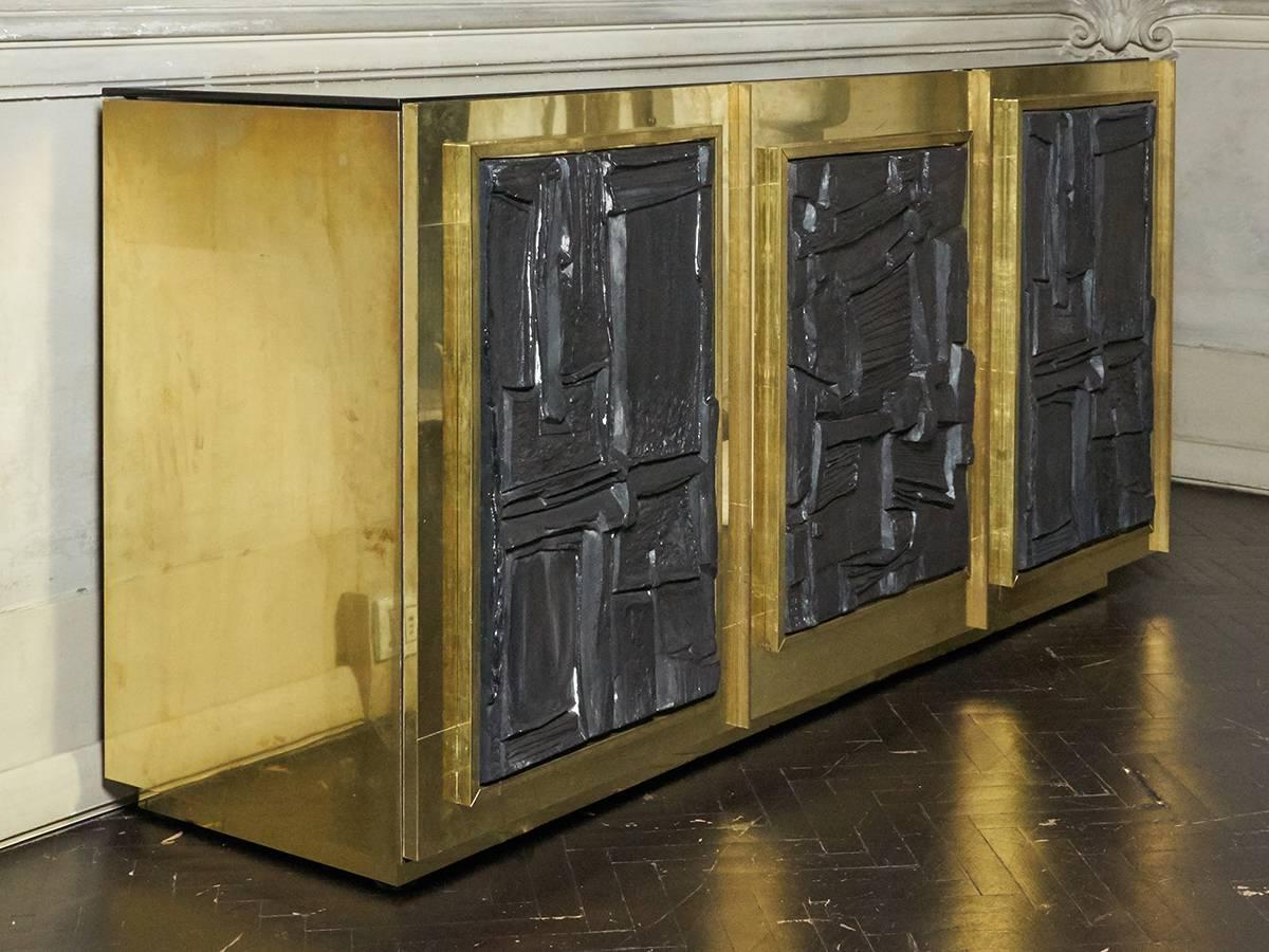 Sideboard entirely covered with unvarnished brass for a vintage look, the sculptural plaster panels are from the french artist Roger Desserprit Atelier, the inside shelves are not adjustable.