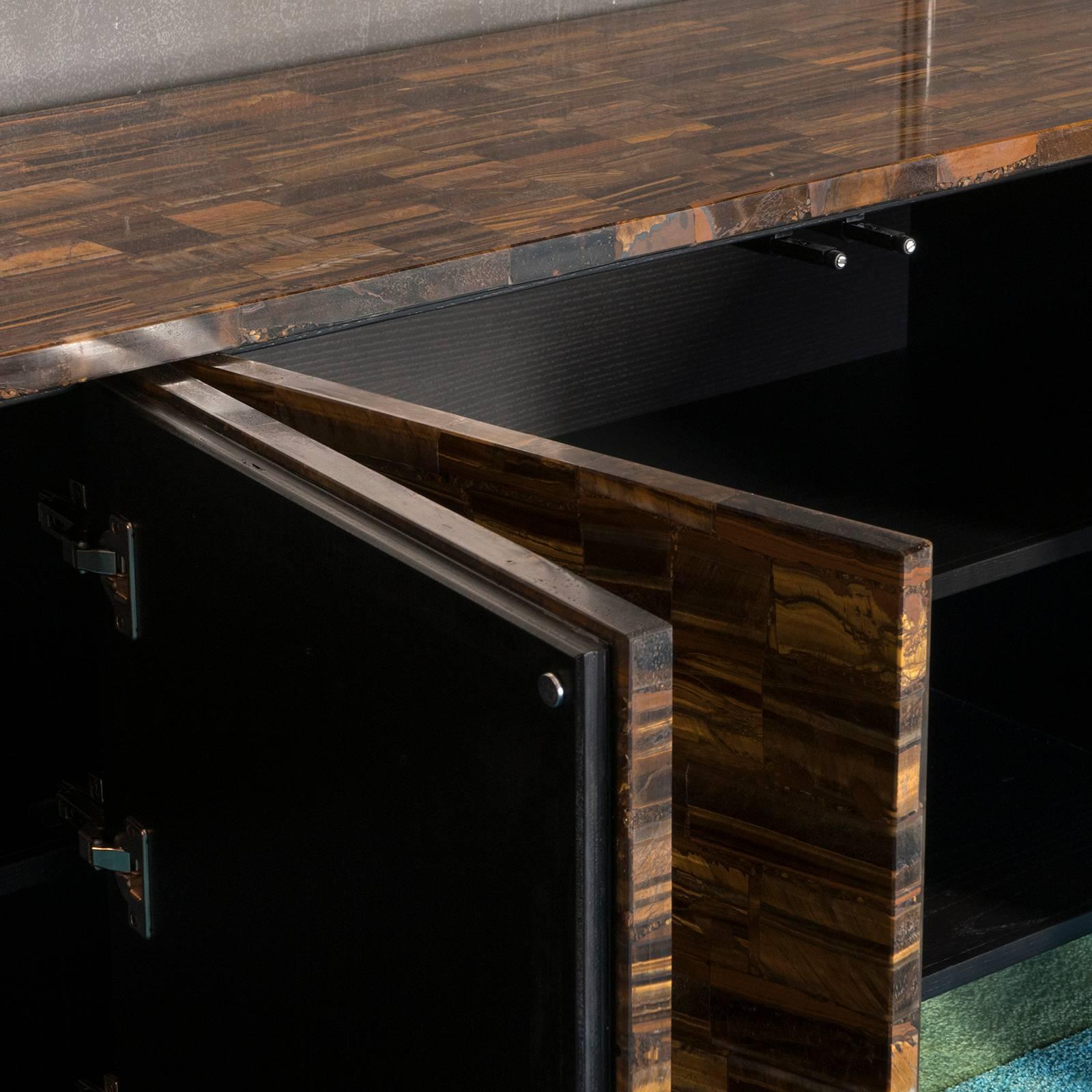 Tiger eye gold marble sideboard, removable top, four doors, brass base and backside, ebonized wood inside with one shelve.
