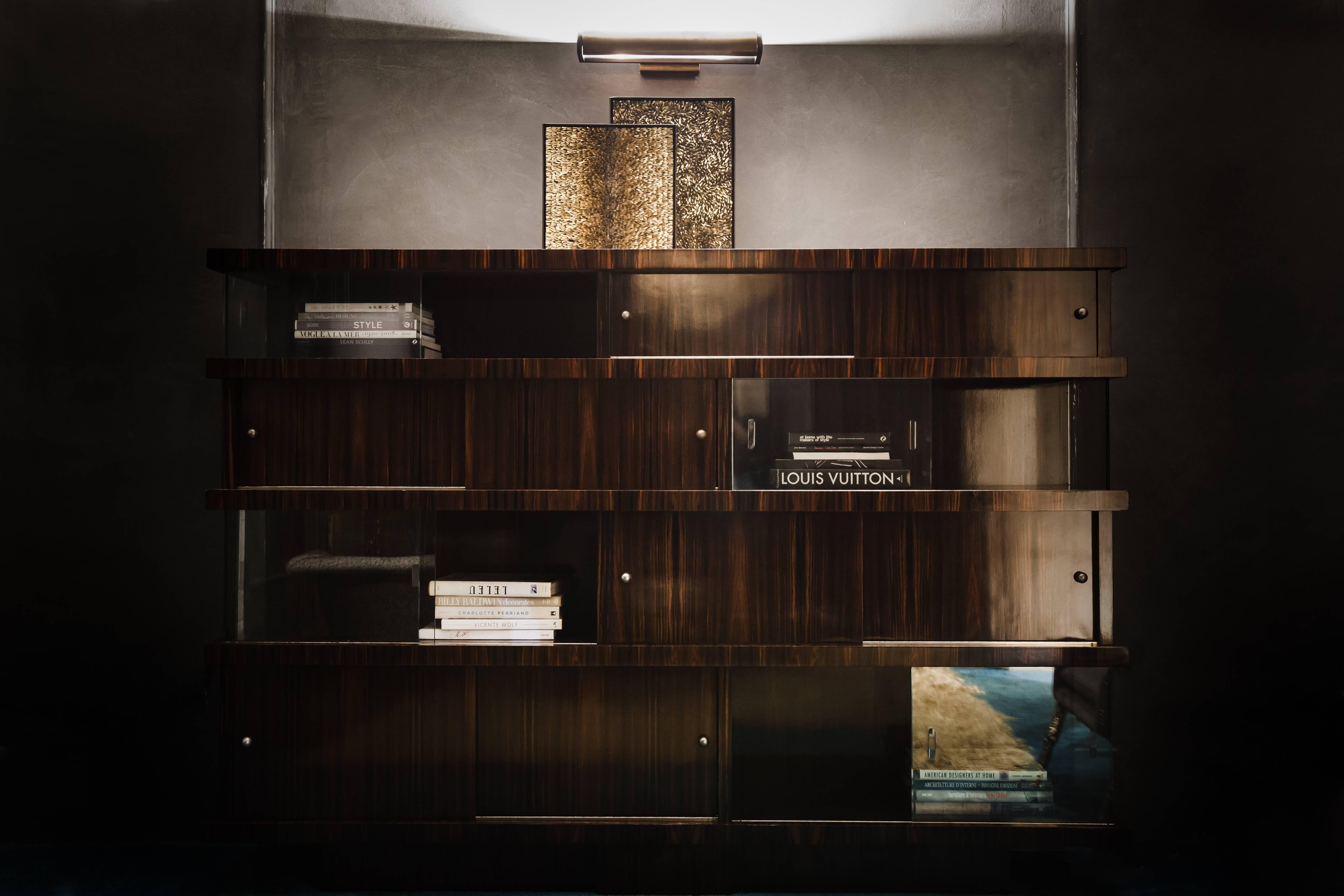 Modernist Bookcase by J.Adnet custom made in Ebony Macassar veneer with sliding doors with brass round pulls