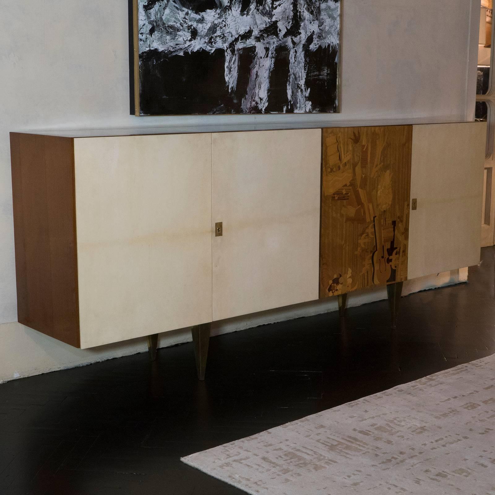 Mid-Century Italian sideboard in lacquered oakwood, parchment covered doors and one with an inlaid design with various tones of woods, one interior shelve each side, beautiful vintage patina.