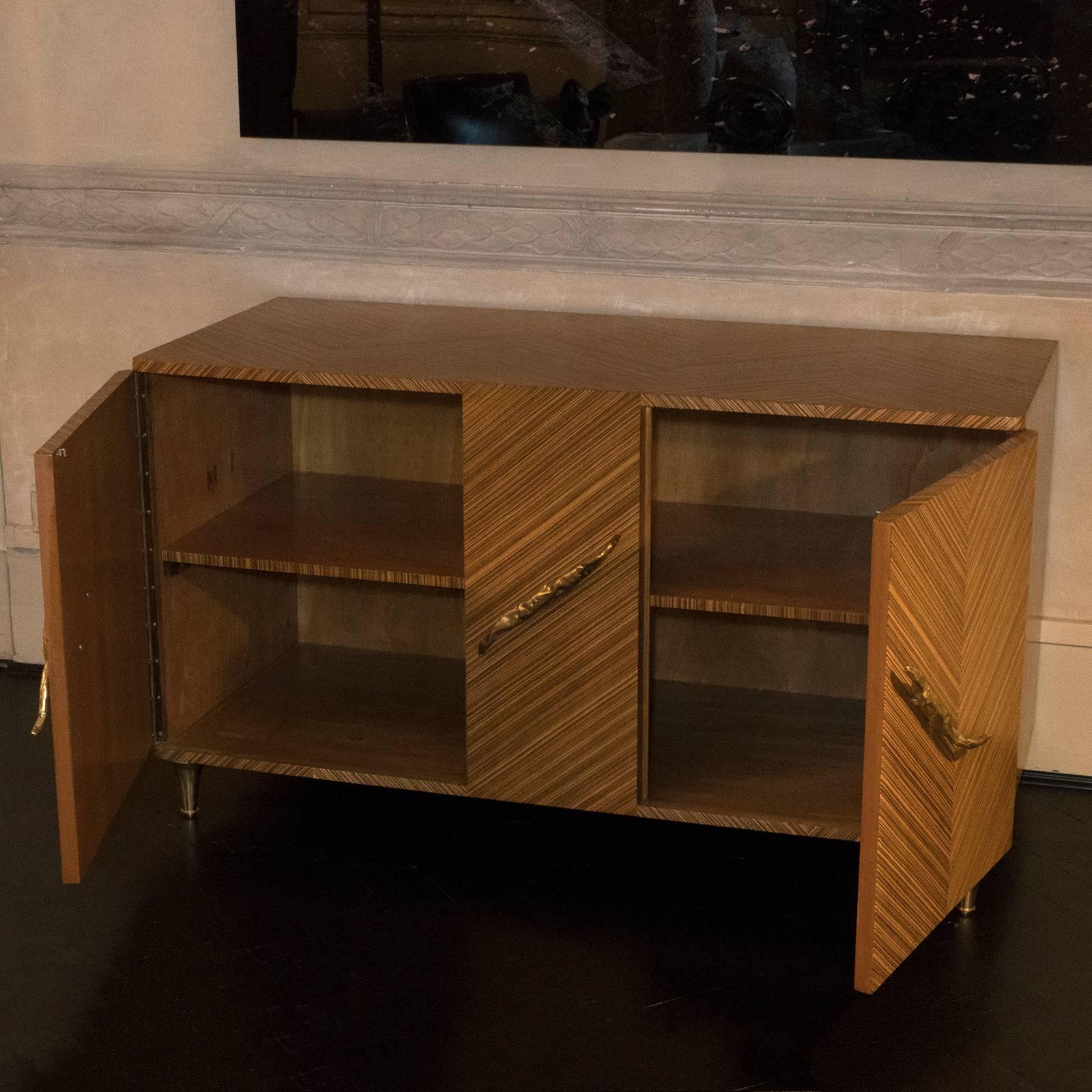 Original vintage structure newly covered with a Zebrano wood veneer, original brass handles and brass feet.
 