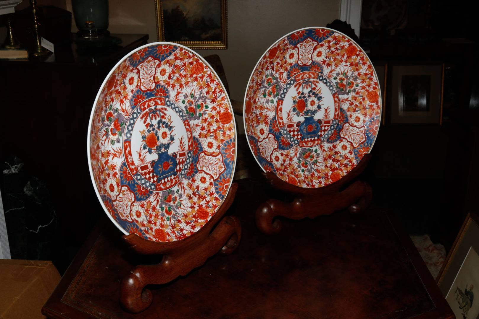 Pair of Chinese early 20th century, possibly late Qing dynasty chargers in the Imari palette. Featuring a central ground decorated with a vase and flowers surrounded by a band and an outer field of foliate designs with three cartouche panels. Wood
