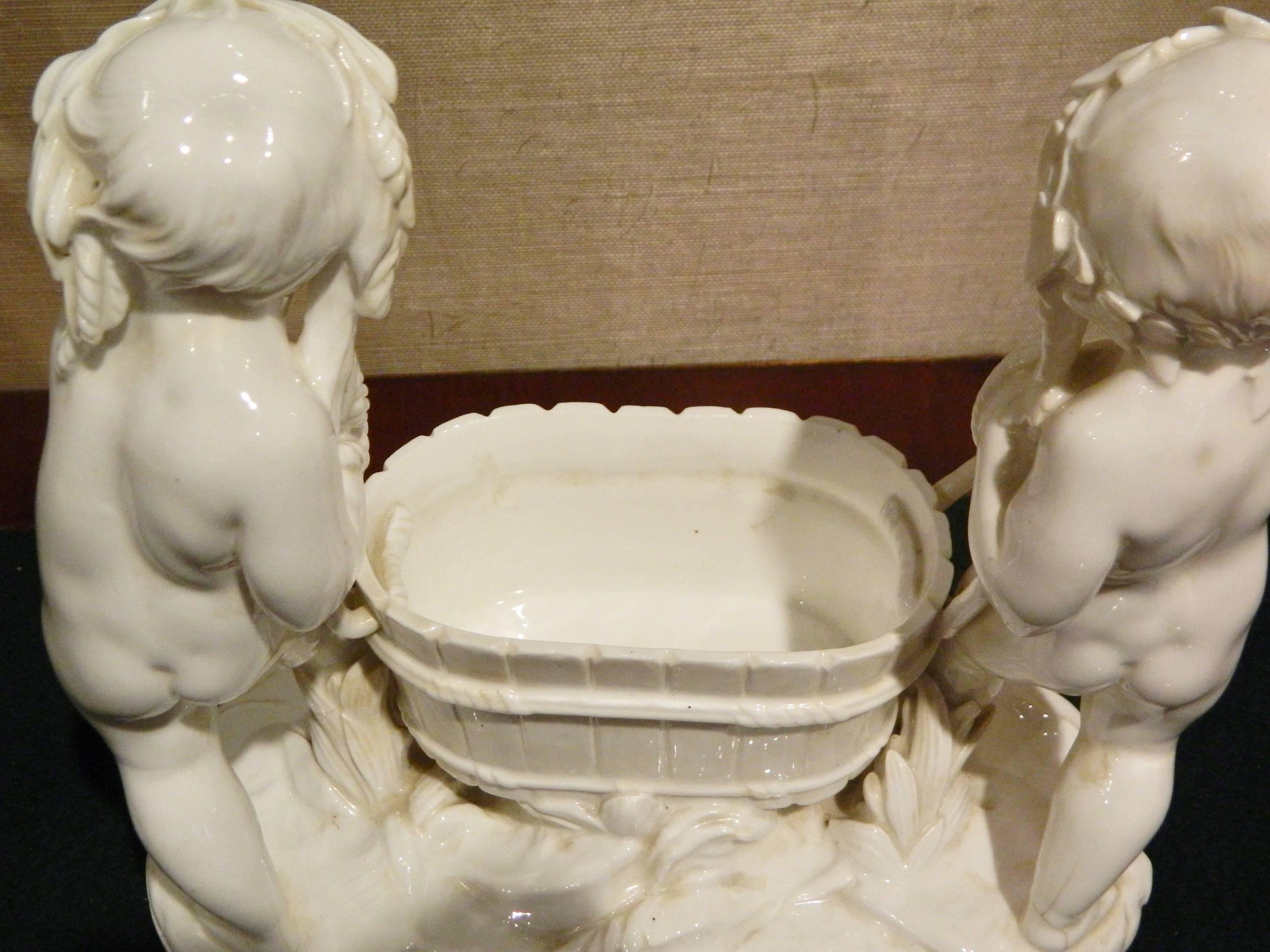 German porcelain figural Jardiniere depicting putti harvesting grapes with a large basket, Late 19th-Early 20th Century.