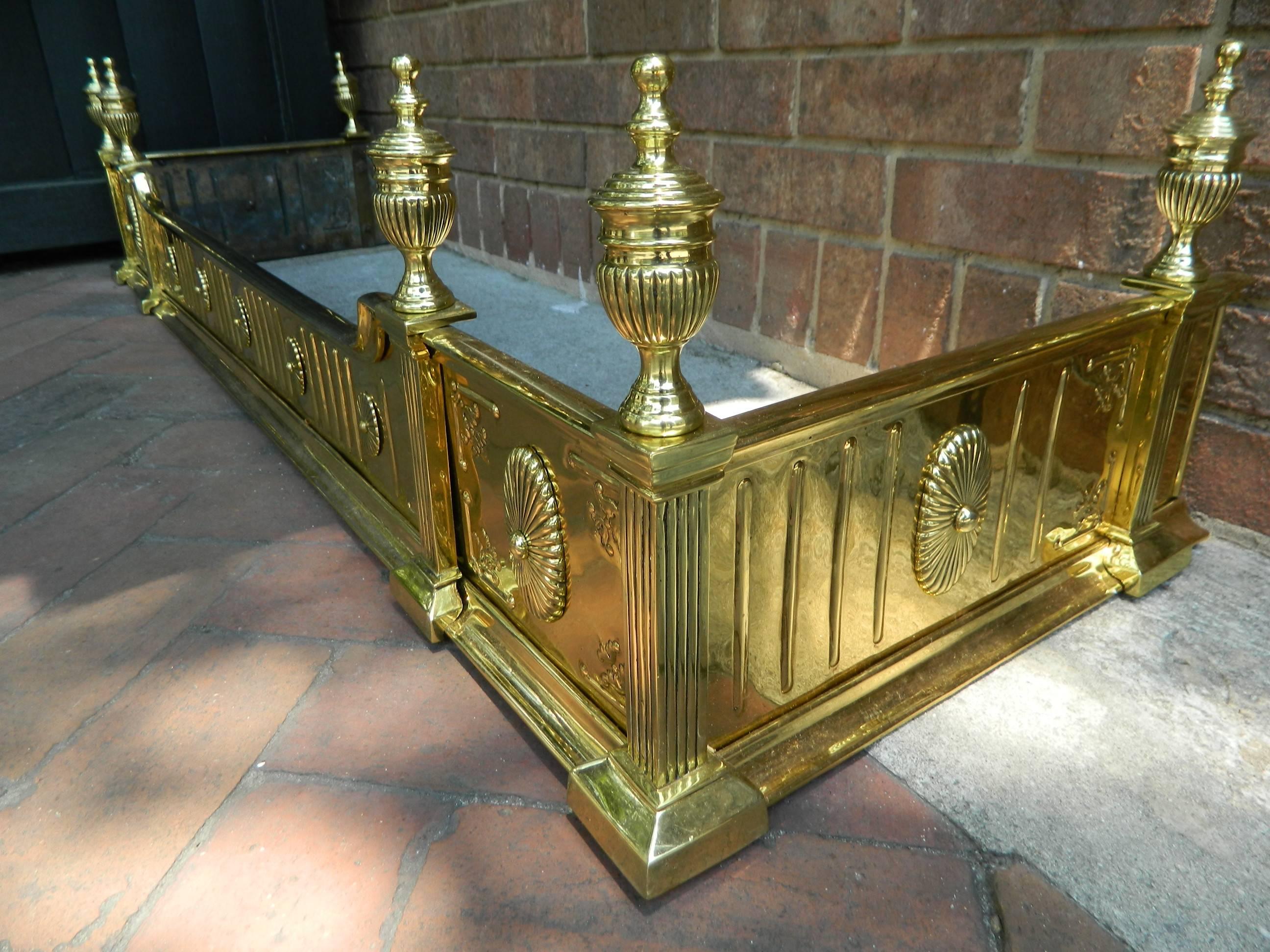 English polished solid brass fireplace fender adorned with finials, 19th century. Professionally cleaned and polished.