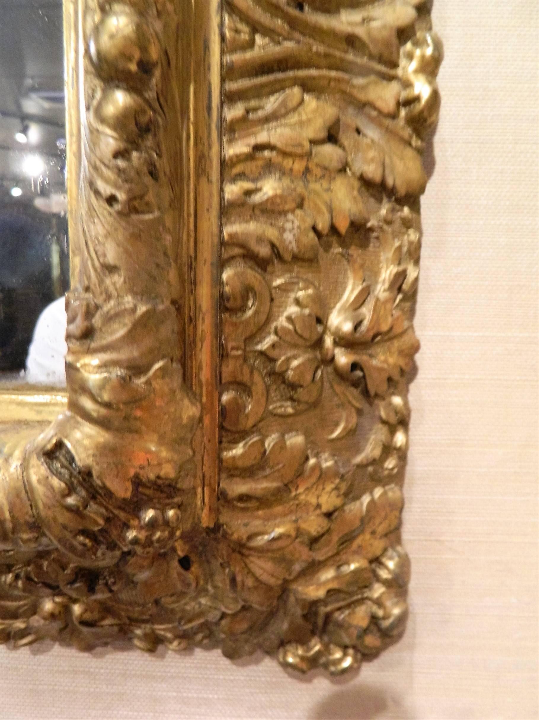 English gold leaf and water gilding trim mirror with floral bouquet motif decoration, circa 1850-1880.
      