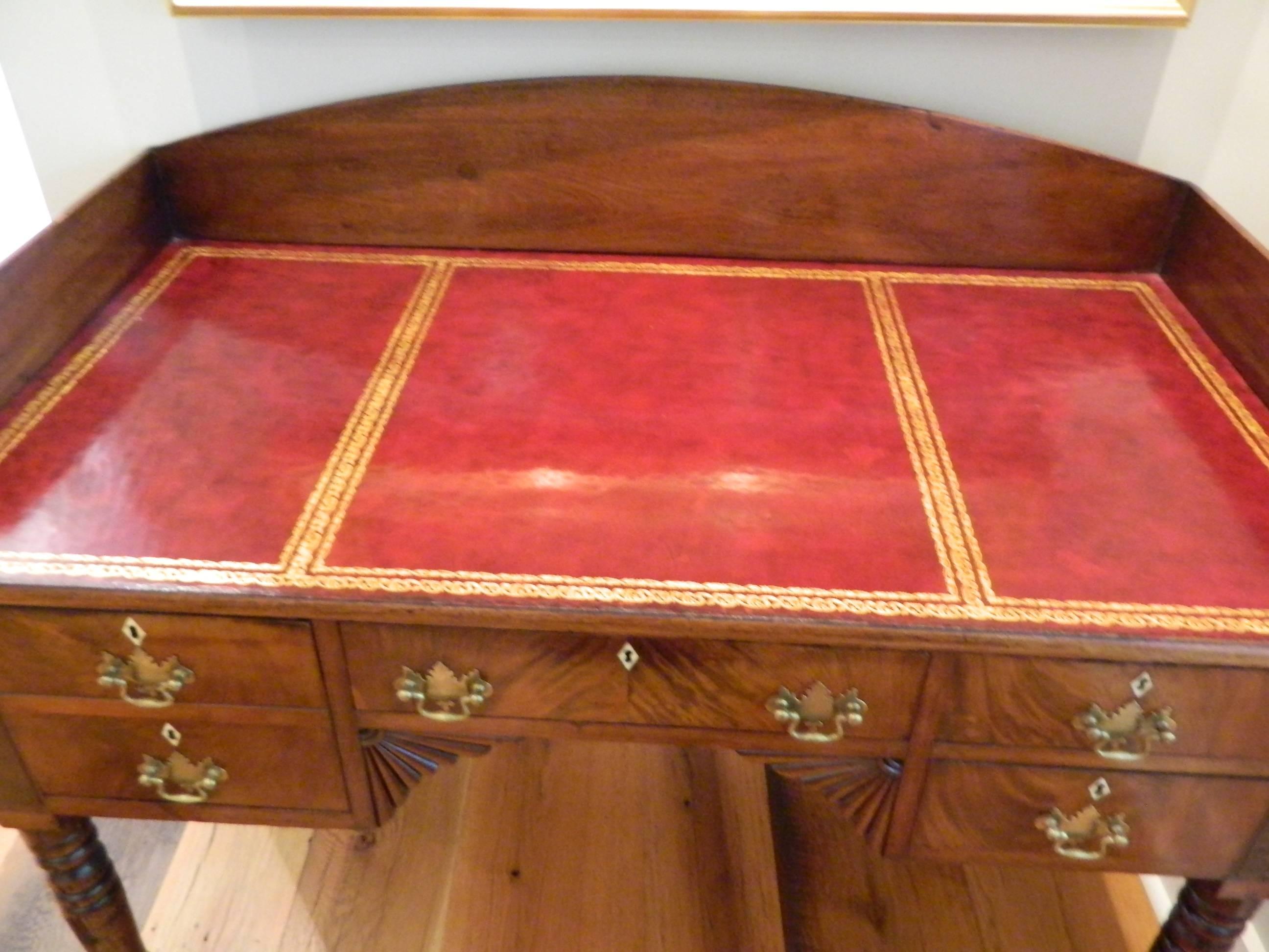 William & Mary mahogany desk with a red leather top, 19th century. Height to desk top is 30.75". Height to bottom of center drawer is 25".
 