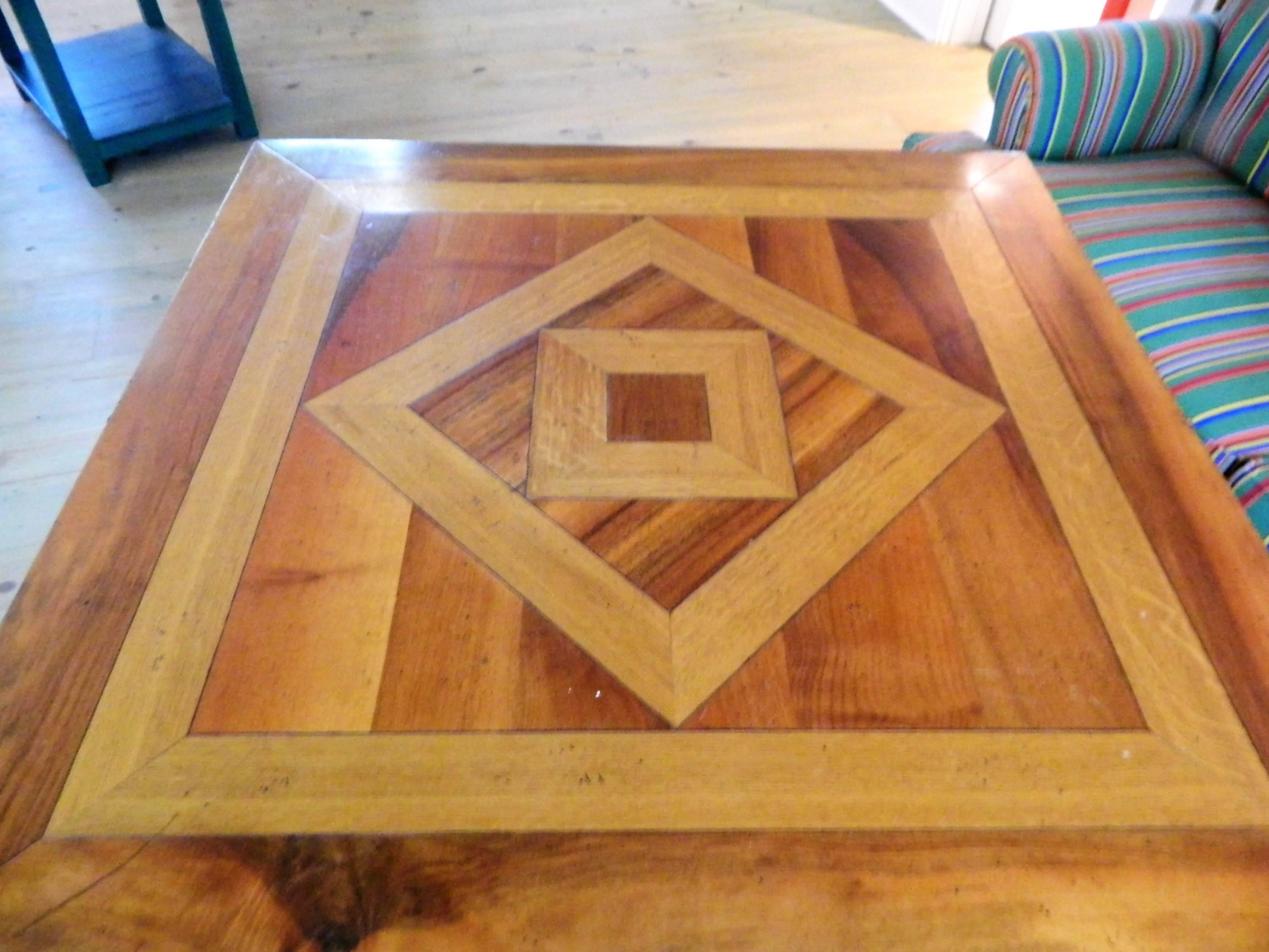 Custom-made square marquetry dining table with inlay design, 20th century.  When all four sides are extended, it measures 55" x 55".  When they are closed, the table measures 39.5" x 39.5"
 