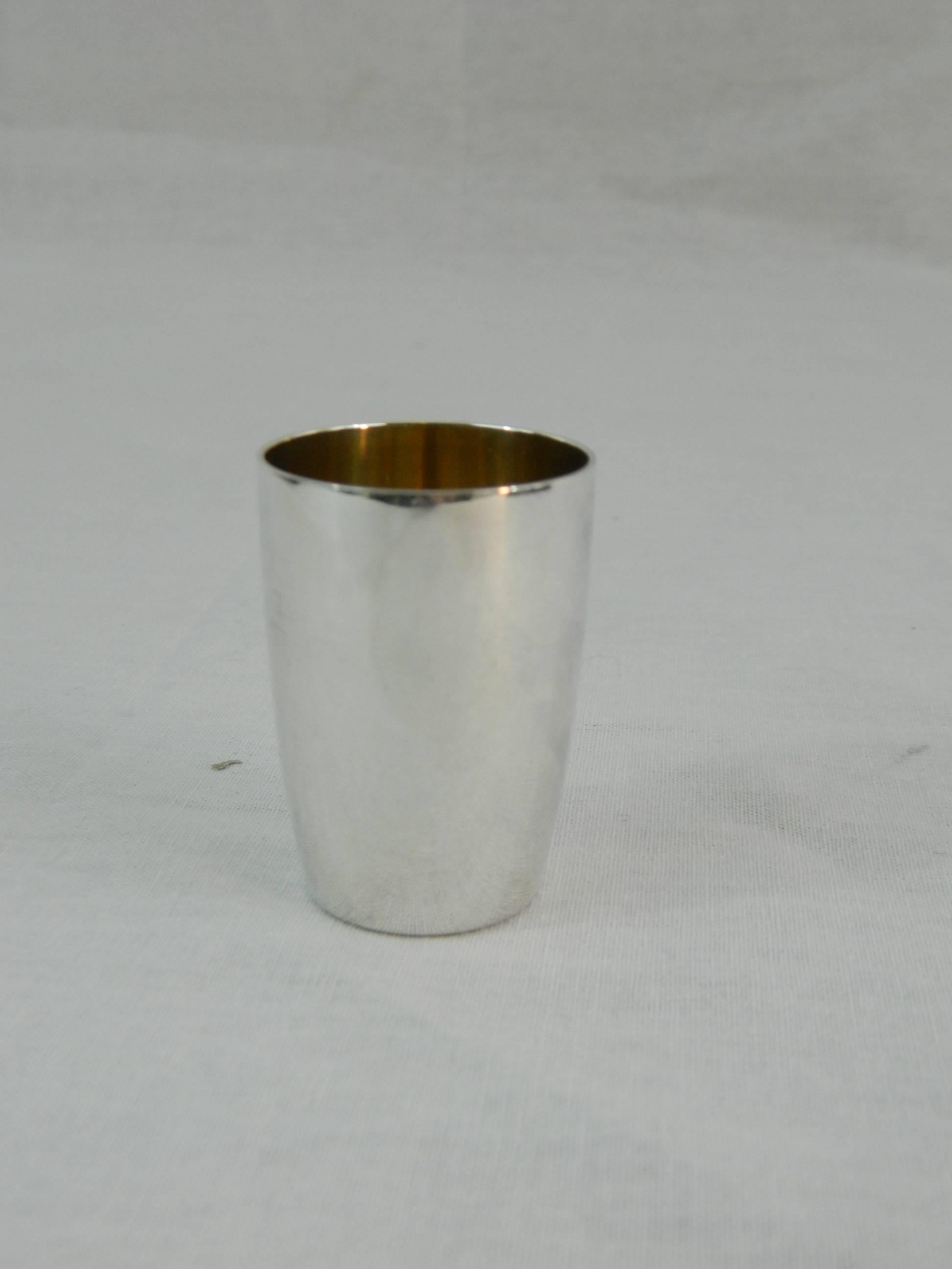 Set of four Tiffany & Co. sterling silver shot glasses, early 20th century. Gold interior.
