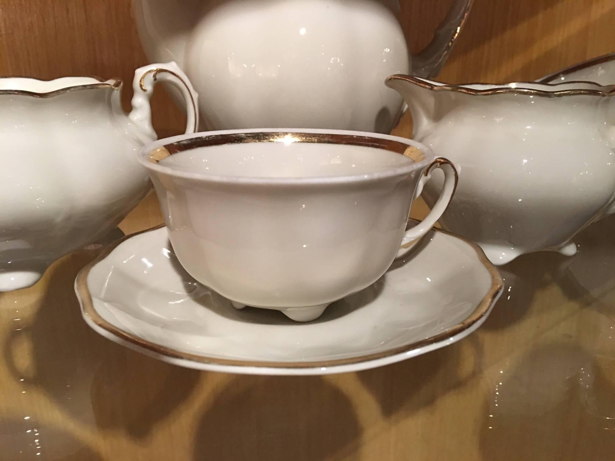 German Veritable Porcelaine Sofafils Tea Set.  White with a Gold Trim.  (2) Tea pot with lid, (1) sugar bowl, (1) creamer, (12) tea cups, (9) saucers.  Early 20th Century
