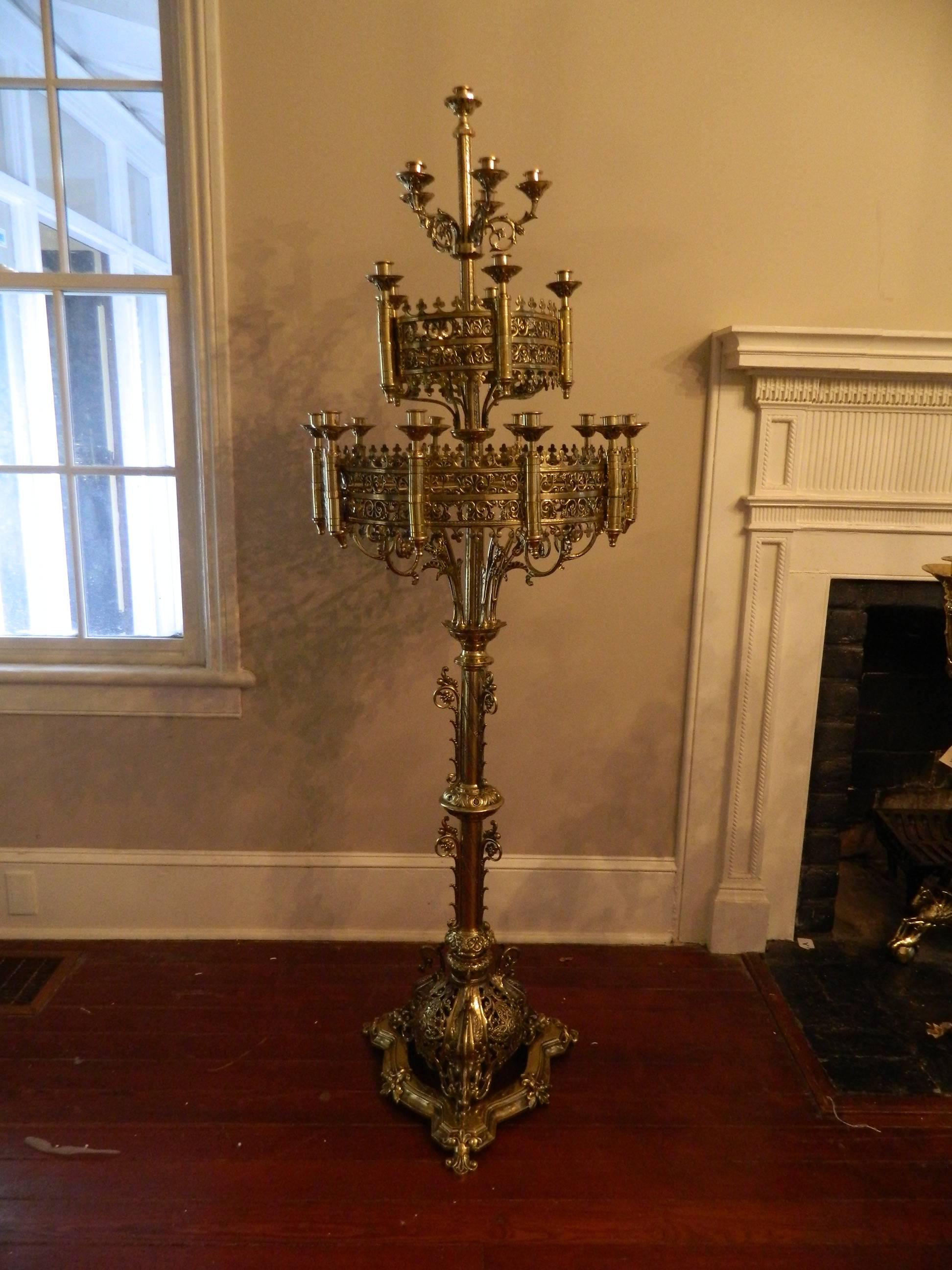 Pair of large floor standing brass candelabra, circa 1860. 20 candle candelabras adorned with scrolls and ending on a triangular reticulated base.
 