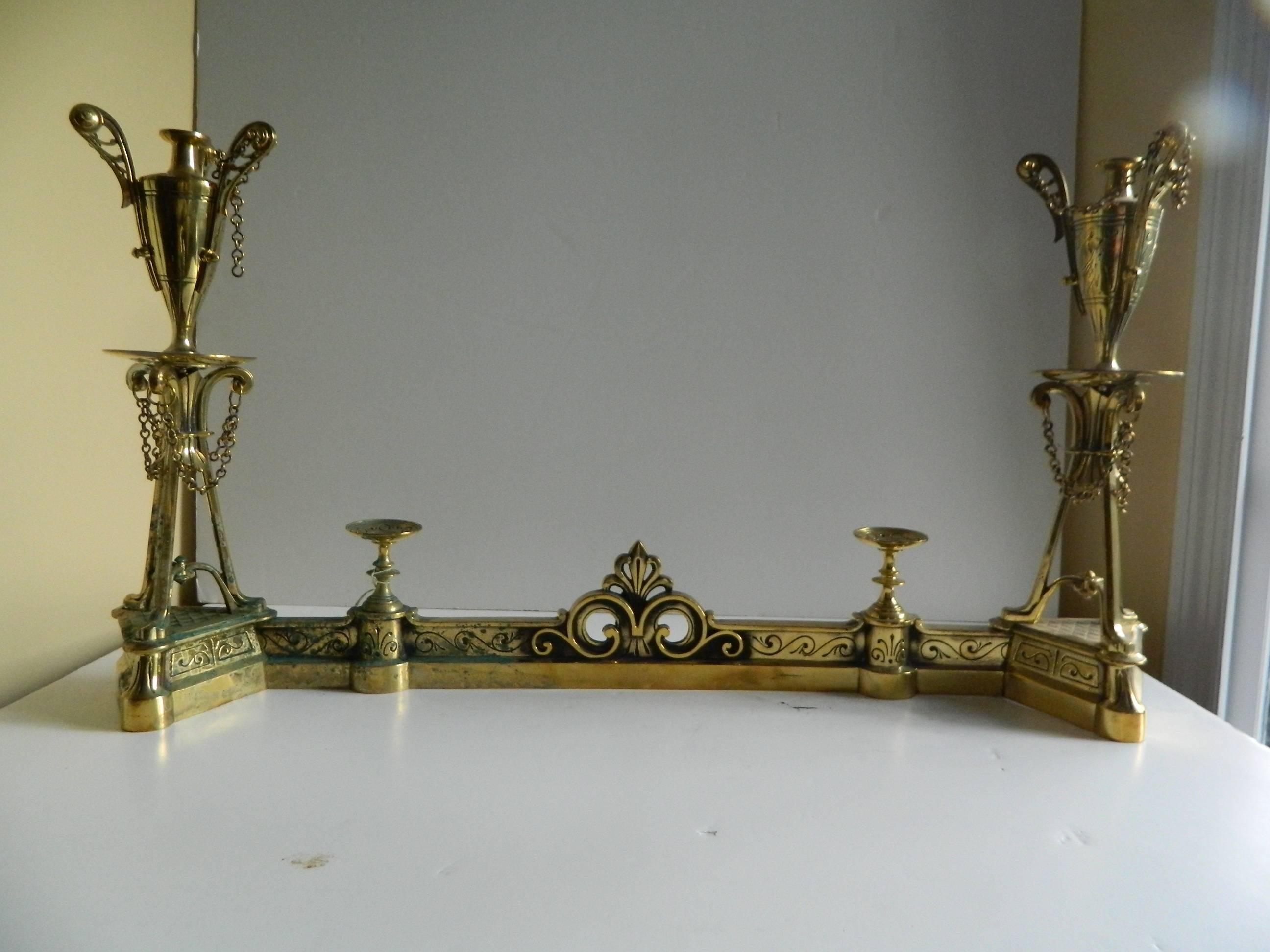 Paire de chenets ou chenets à ailettes en laiton poli - motifs d'urnes et de tazza, XIXe siècle.
    