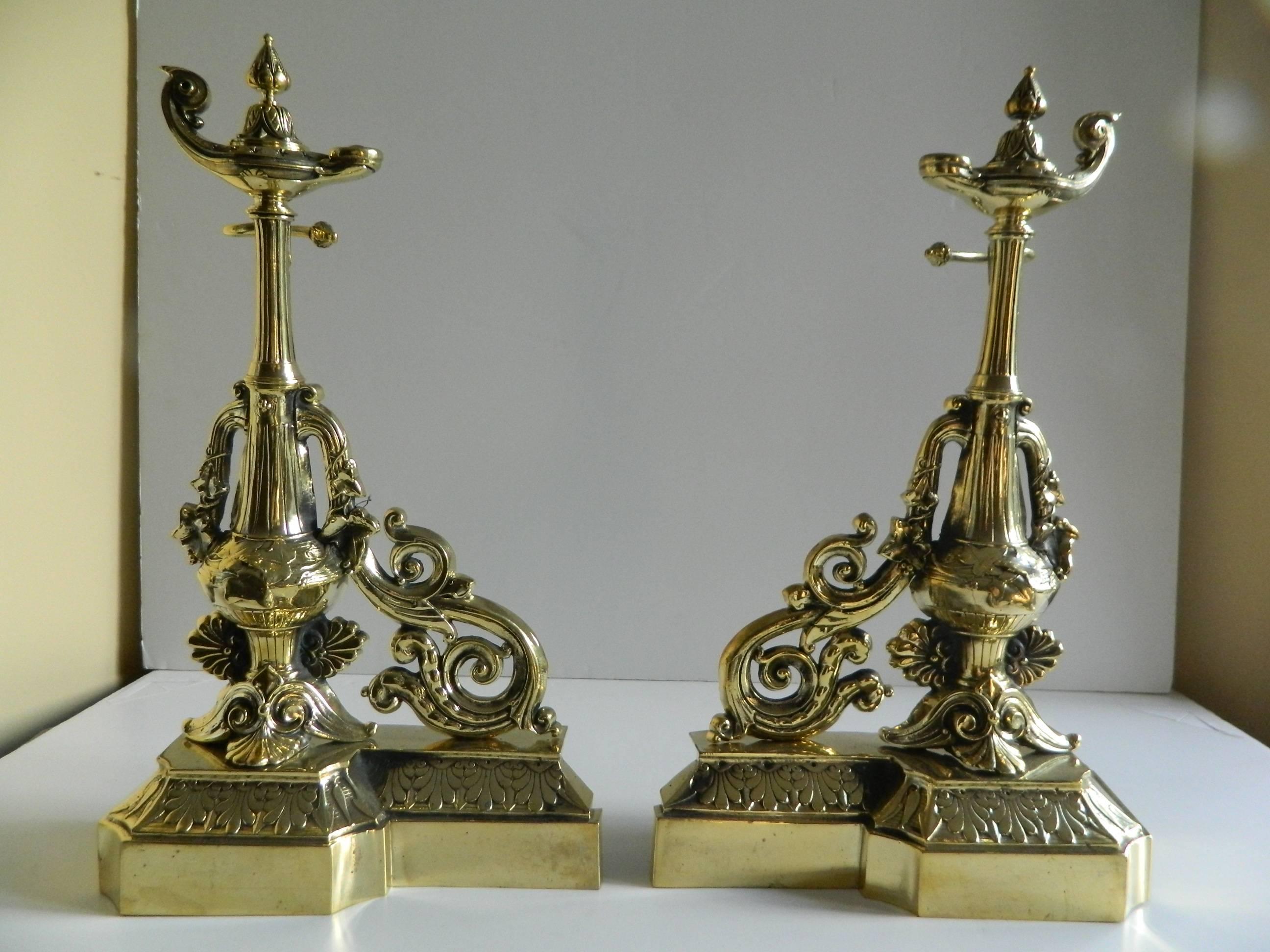 Pair of brass chenets or andirons, magical or oil lamp motif, 19th century.