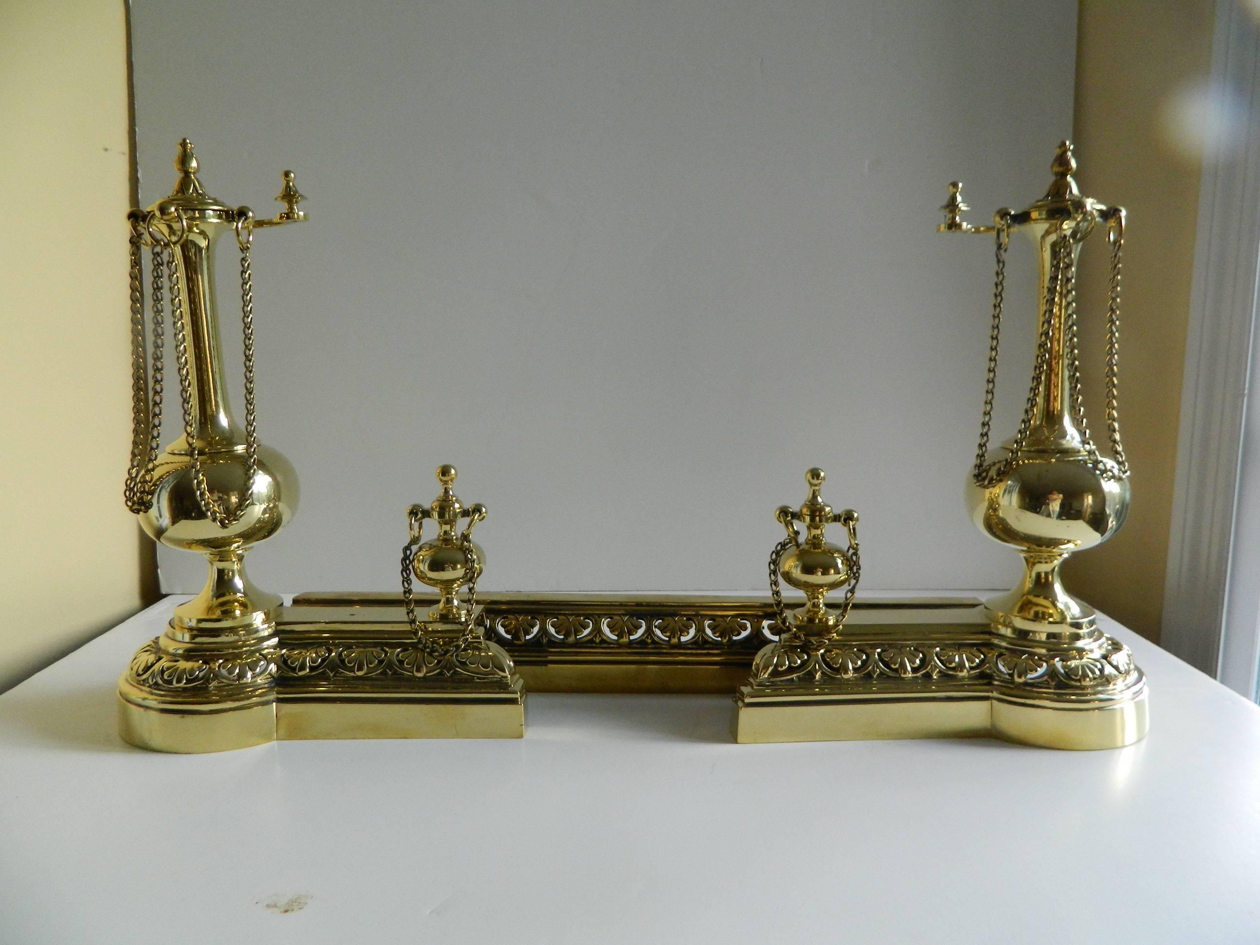 Pair of polished brass chenets or andirons with fender, 19th century.
 