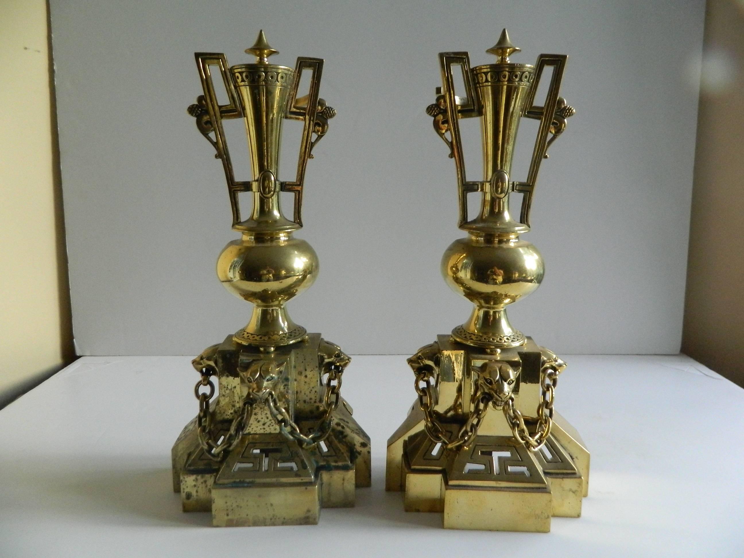 Pair of polished brass chenets or andirons, panther heads motif, 19th century.
  