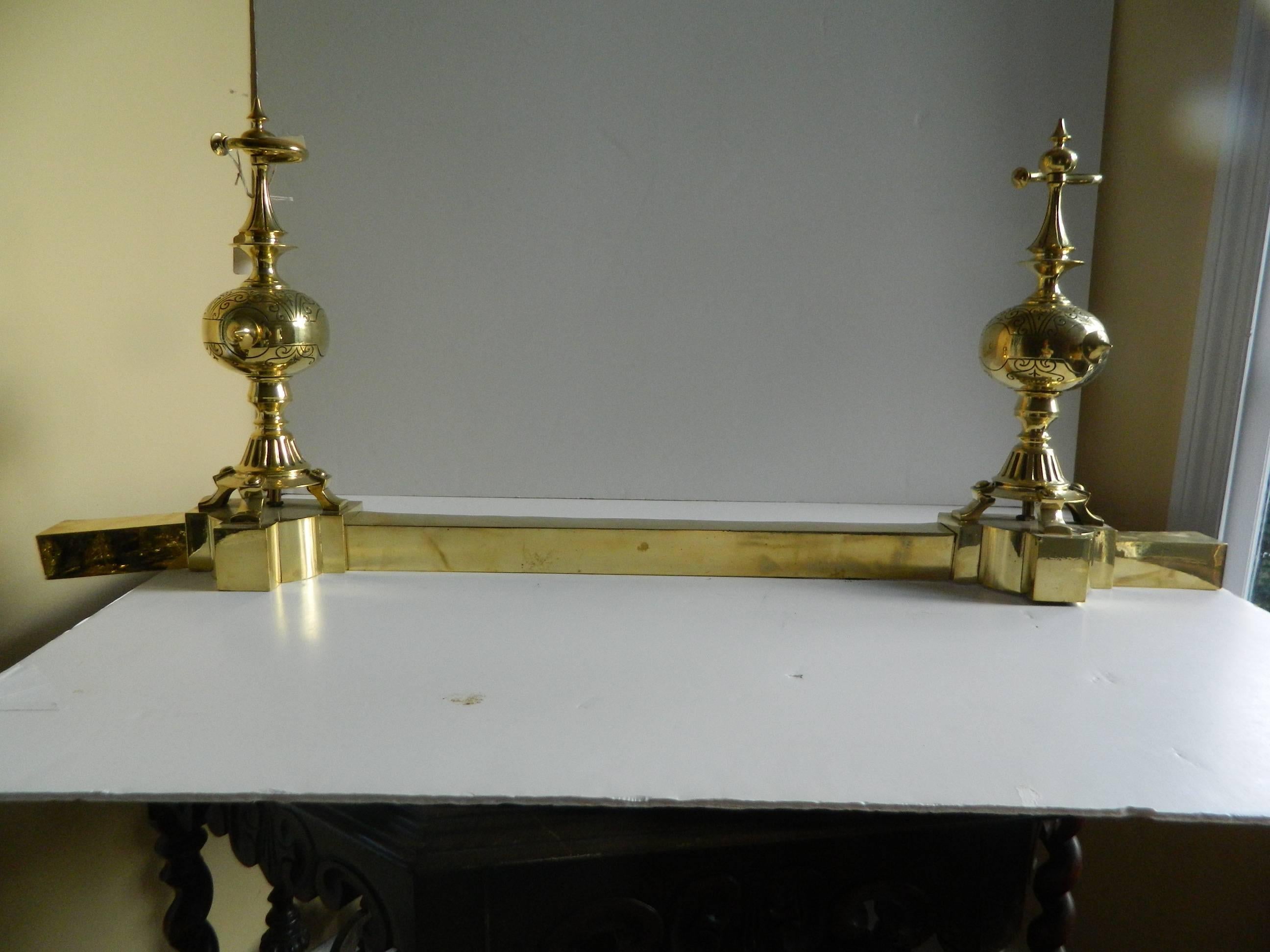 Pair of polished brass chenets or andirons with a fender, 19th century.
 