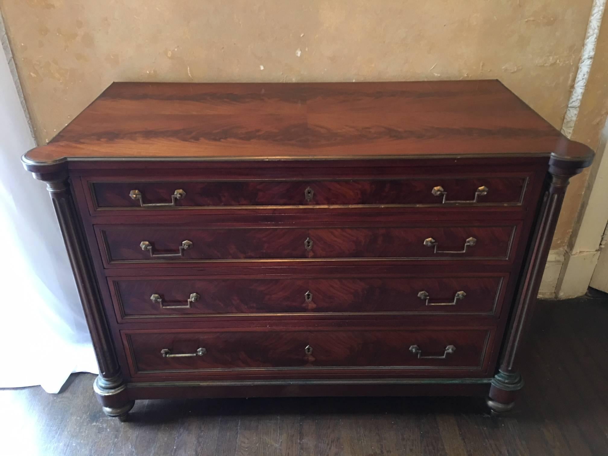 French Empire style four-drawer Napoleonic commode, circa 1850. Brass ormolu columns and crotch mahogany veneer.
 
