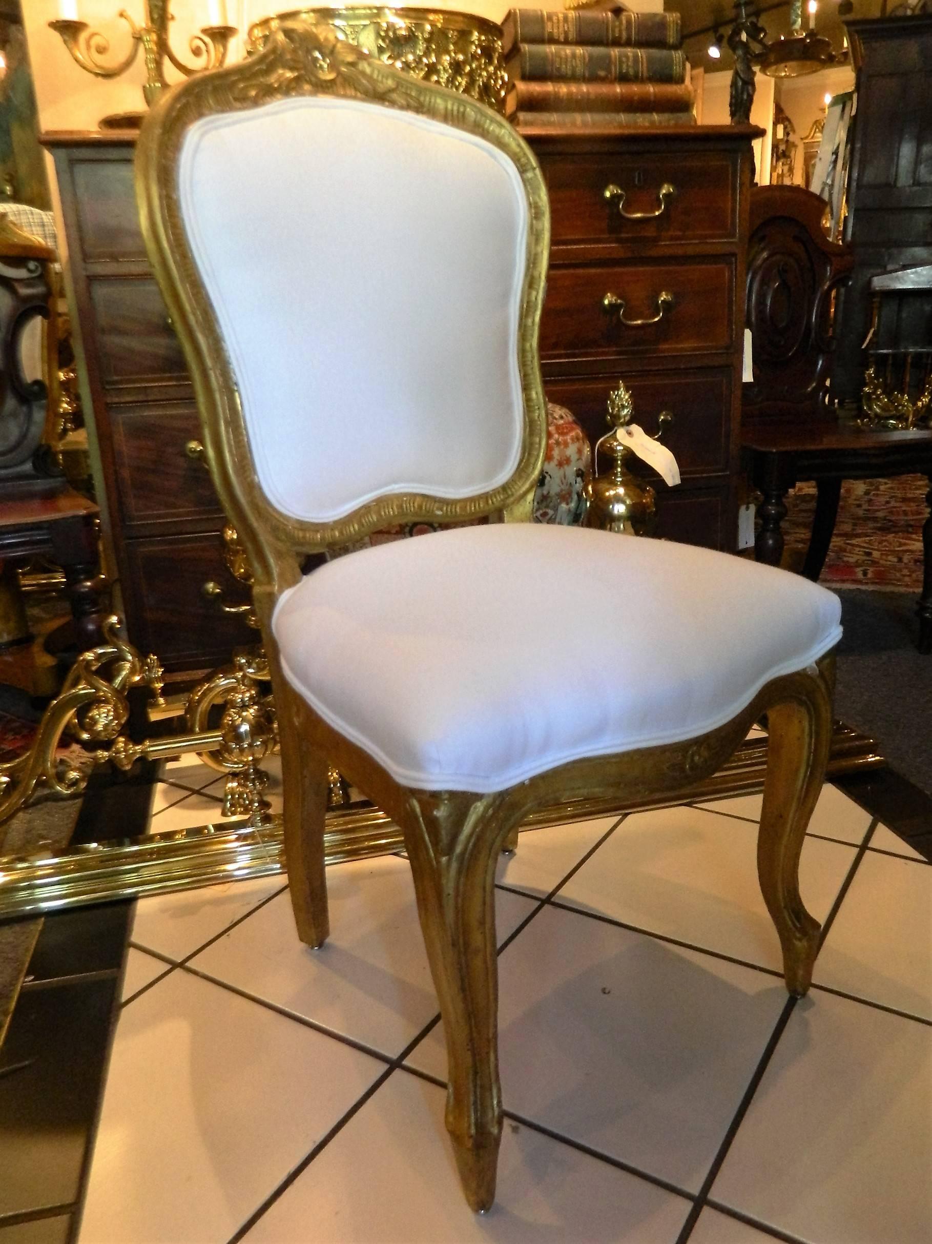 Set of eight Louis XV style giltwood side chairs, early 19th century. Upholstered in off-white muslin.