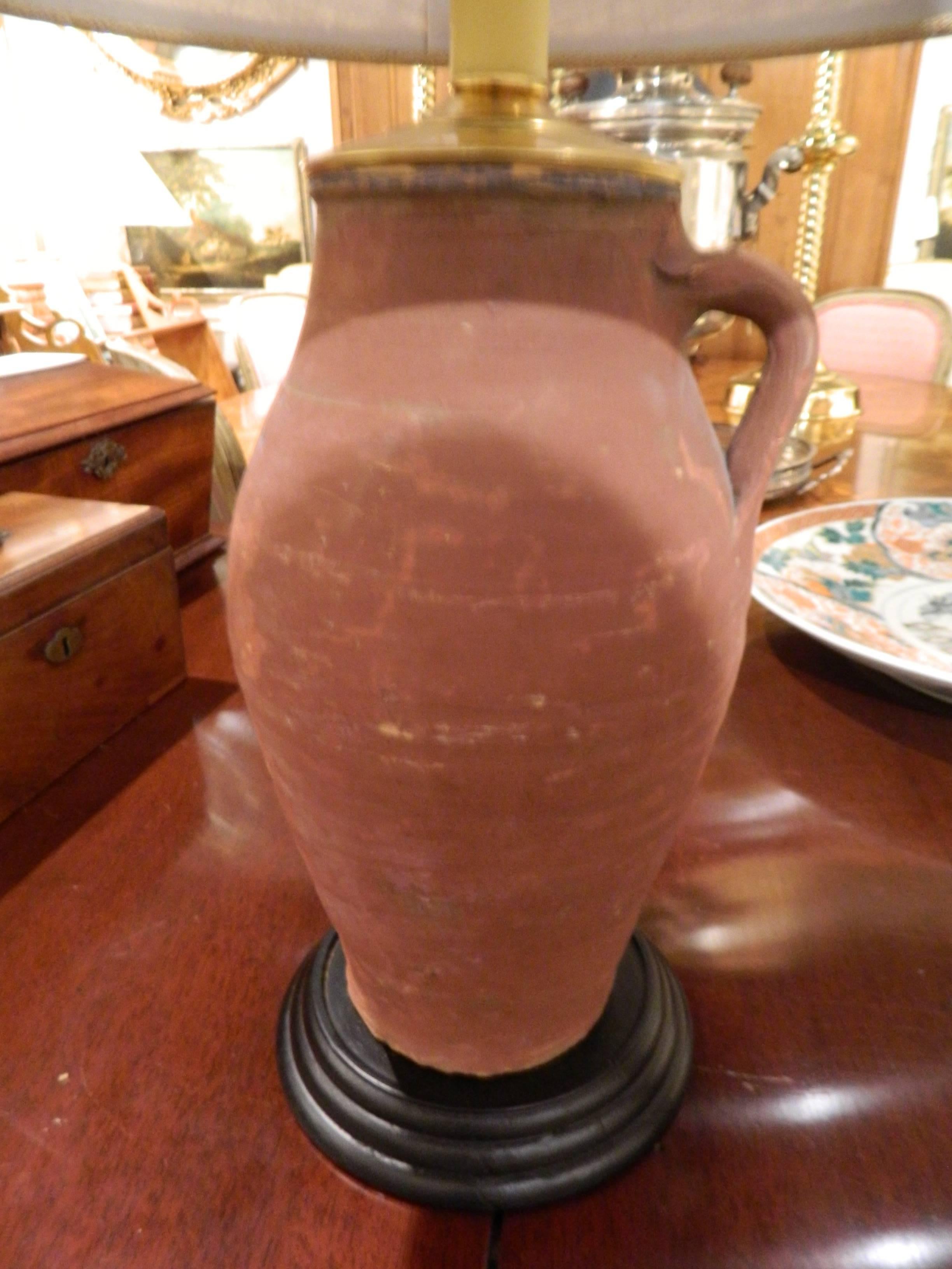 Paire de jarres à huile italiennes en terre cuite avec poignées simples et adaptées comme lampes, 19e siècle. Equipé d'abat-jour en toile de jute.  La hauteur des bases, sans le raccord de l'ampoule ni la harpe, est de 12,75