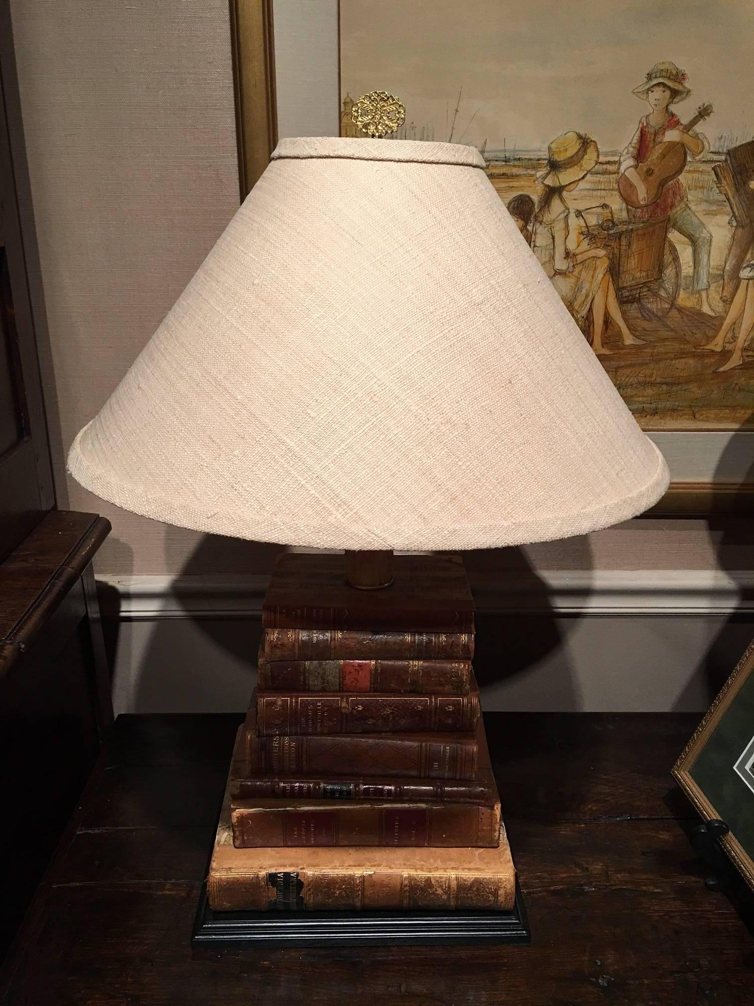 Pair of 18th and 19th century antique books mounted as lamps with linen shades and beeswax sleeves. Wood bases are 12.5