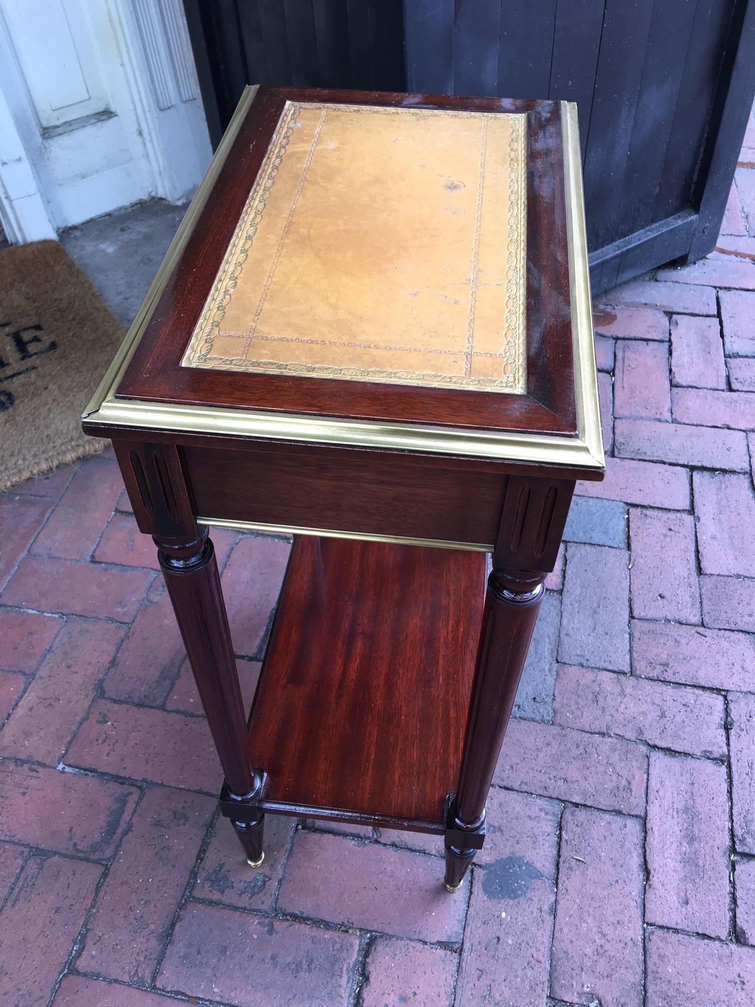 French Directoire Style Mahogany single drawer side or end table with a leather top and a bottom shelf, late 19th century. Decorative brass trim.
 