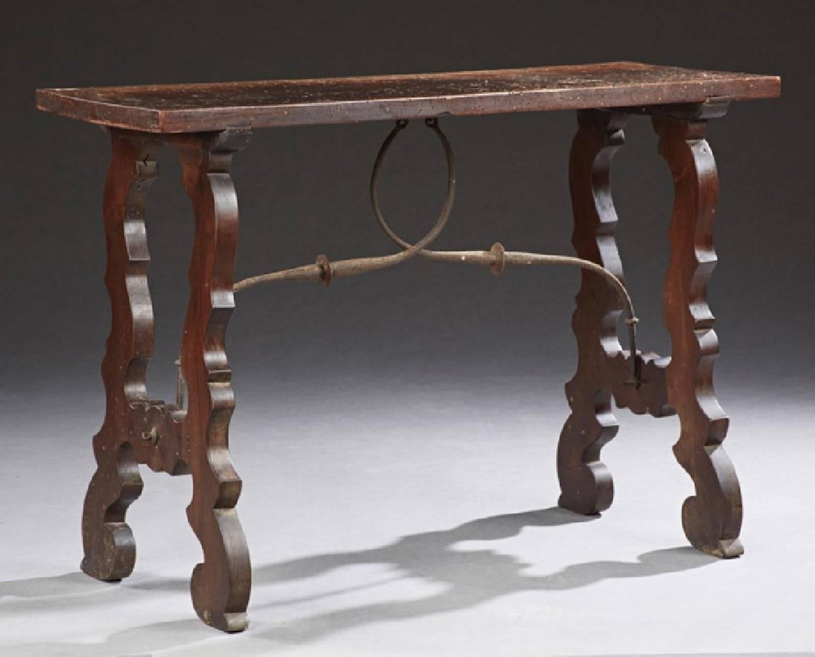 Spanish carved walnut console table, 19th century, the thick top on pierced trestle supports, joined by wrought iron stretchers.
 