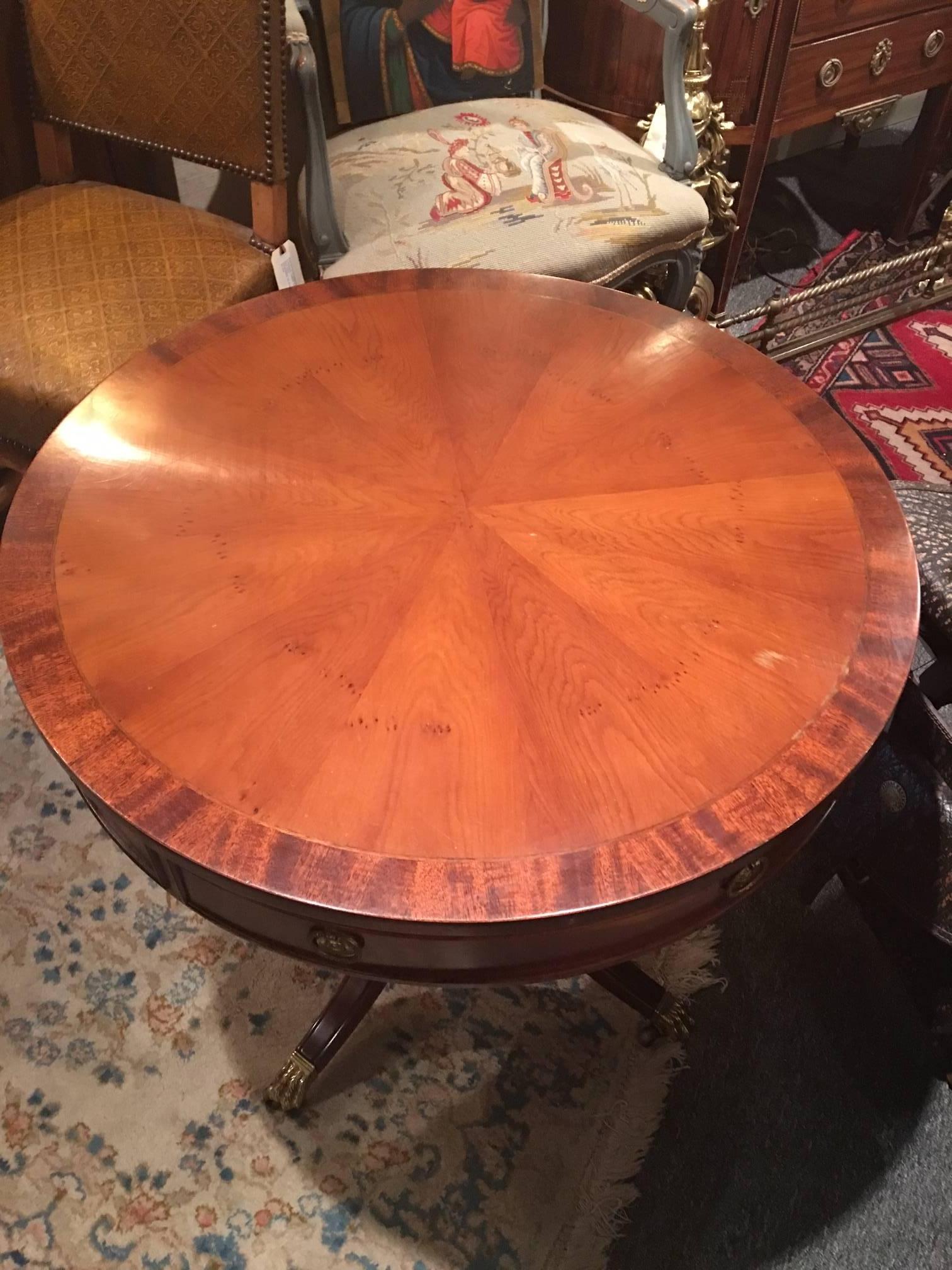 Mahogany round side table with a single drawer on casters, mid-20th century.
