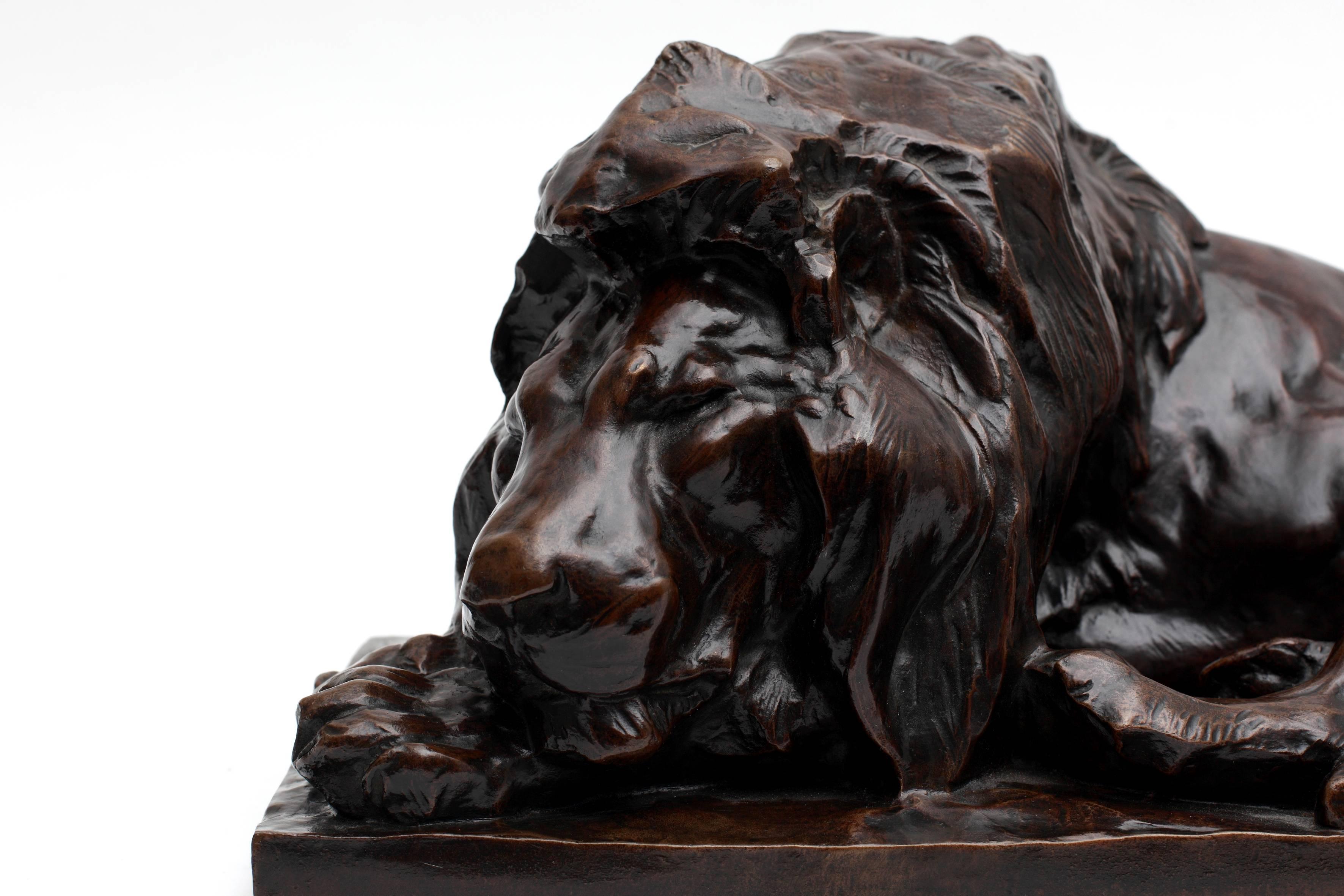 Patinated Reclining Lion Sculpture For Sale