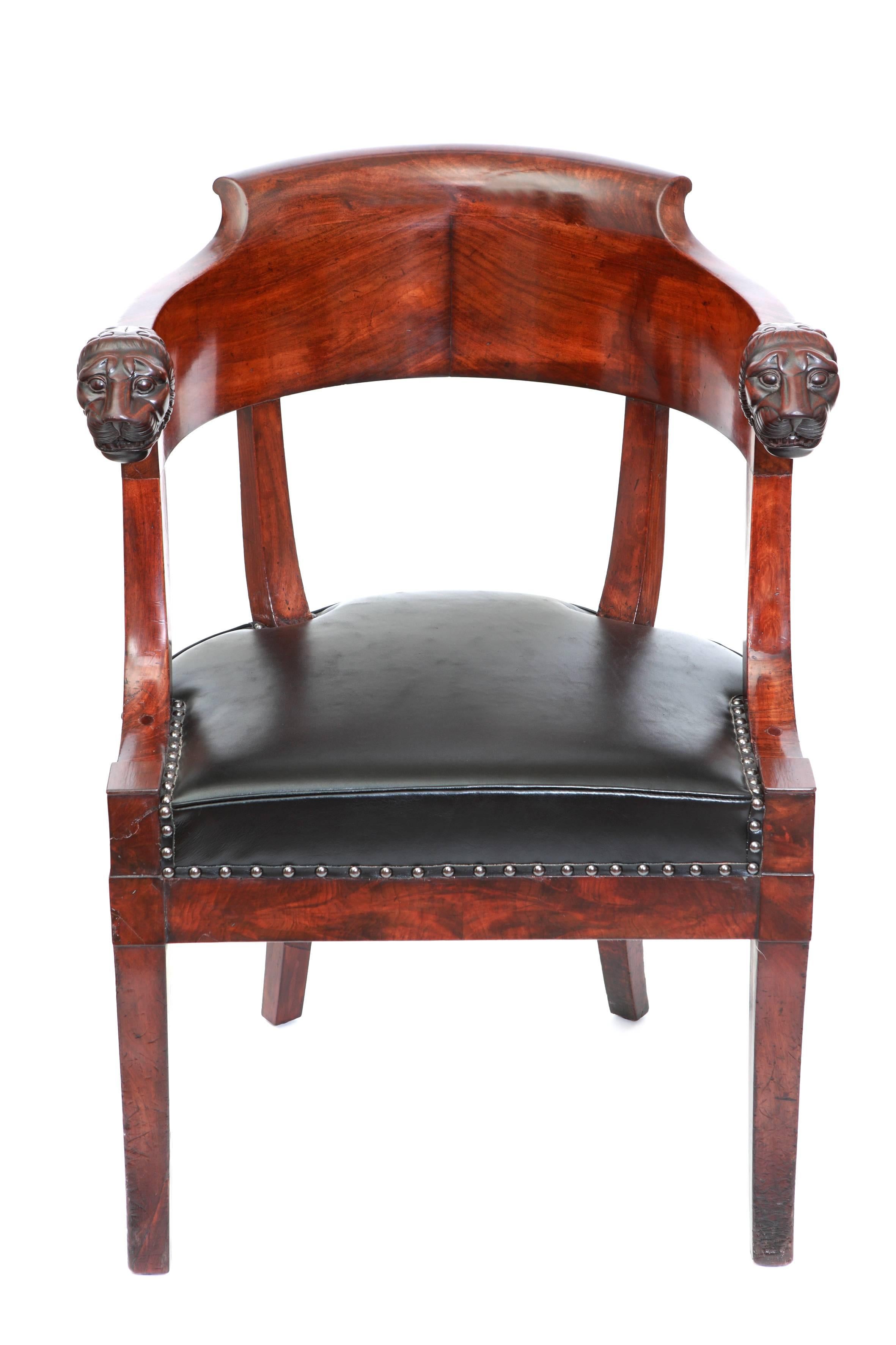 Gondola shaped office chair with armrests ending in lion heads.

Mahogany gondola shaped office chair with upholstery in black leather lined with a spiked border. The armrests are ending in a carved lion’s head. 

Mahogany, black leather