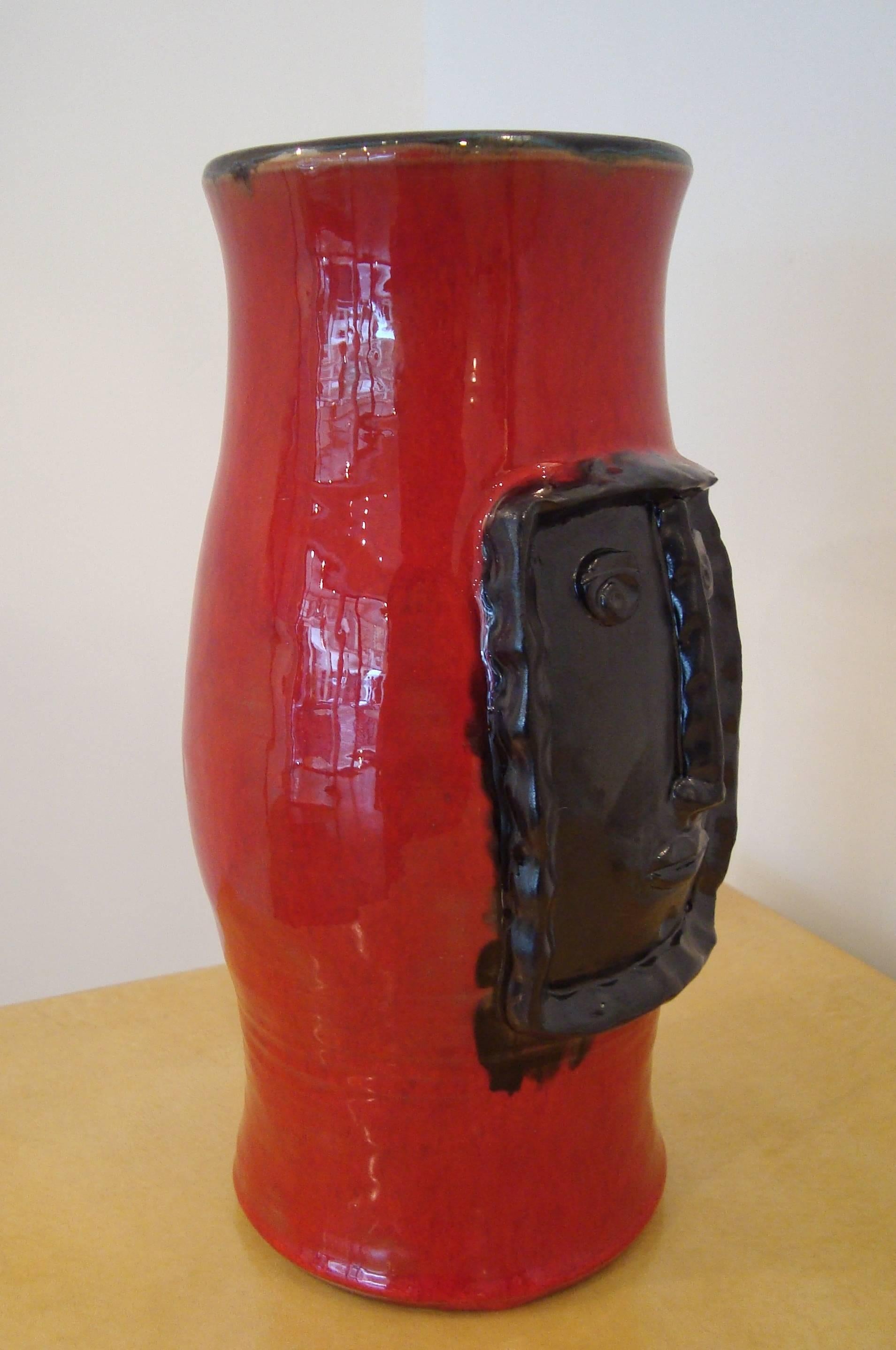 Robert et Jean Cloutier, France (1930-)/(1930-2008.)
Red vase with black relief framed head.
Red enamelled earthenware with mate black.
Signed Cloutier RJ. 
Réf : P.Favardin Les Cloutier, Paris, 2014.

