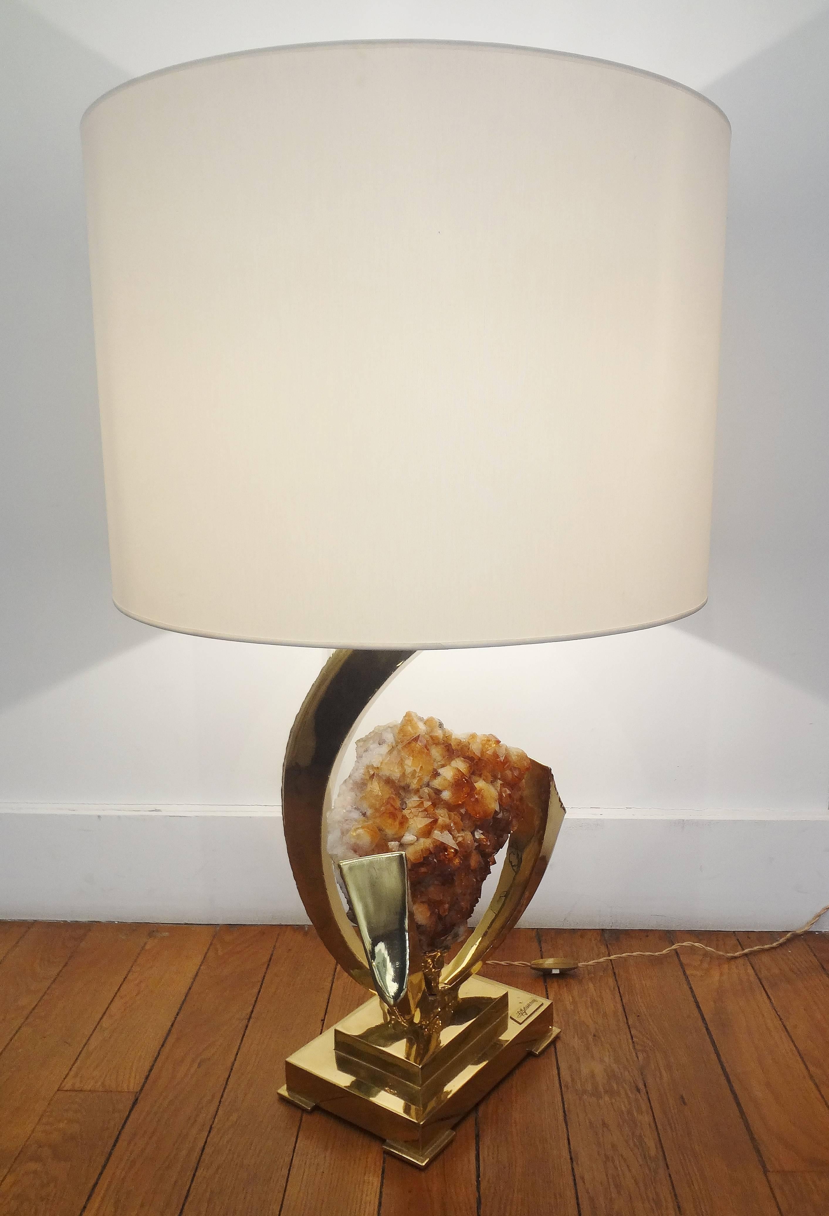 Jacques Duval-Brasseur, (1934-).
Gilt brass sculpted table lamp with an amber rock crystal (yellow quartz) geode, 1970s.
Rectangular lampshade. Unique. Signed.
Measure: Sculpture height 19 x width 12 x depth 8 inches.
Shade height 14 x diameter