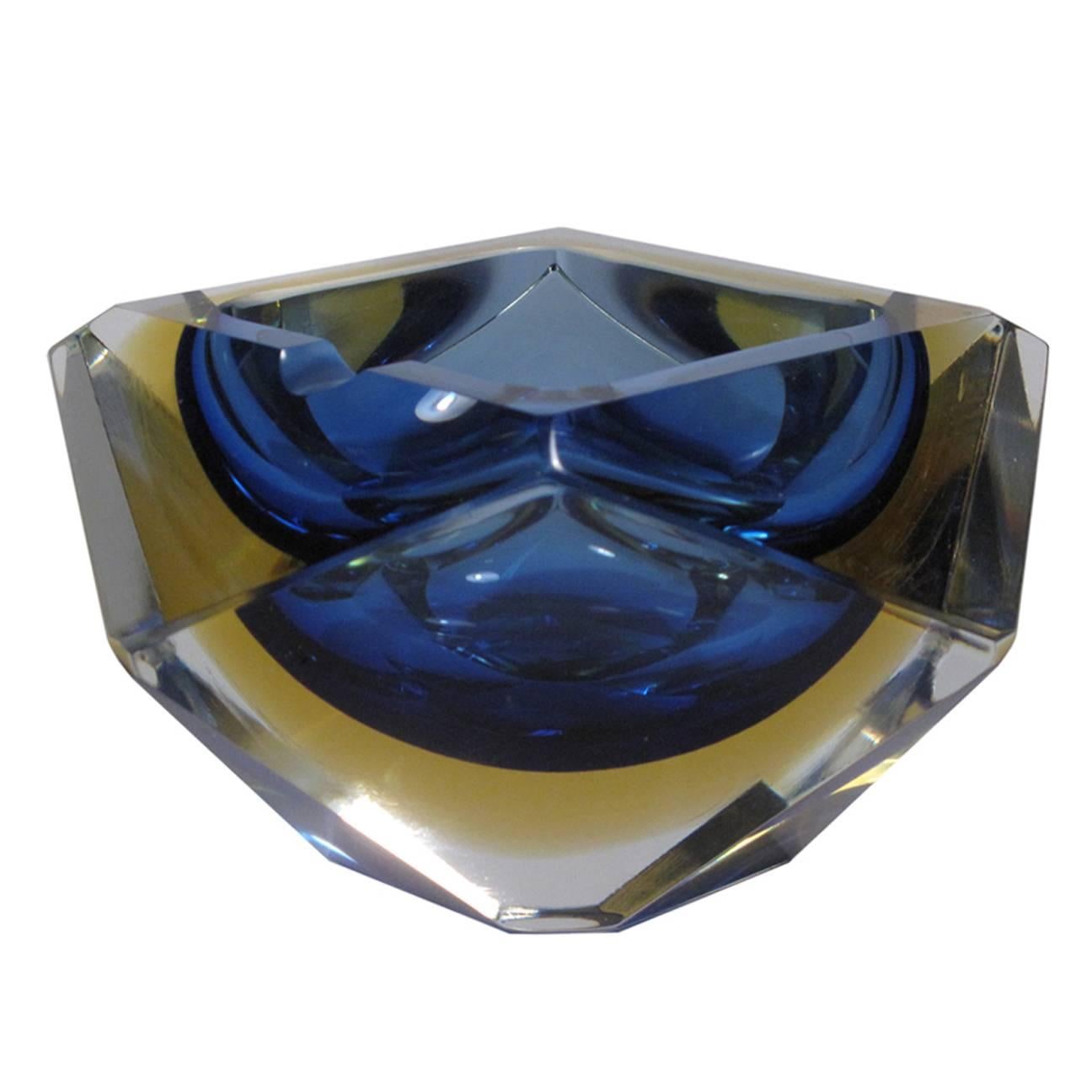 A multifaceted Sommerso Murano bowl/ashtray by Mandruzzato. Layers of blue and yellow are encased in clear glass in this sculptural piece.