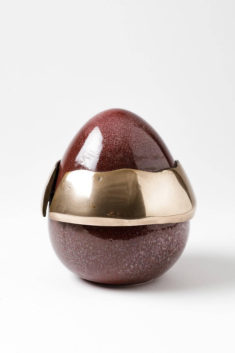 Forme d'œuf élégante de l'artiste Tim Orr.

Porcelaine avec glaçure céramique rouge et pièce de bronze.

Conditions parfaites et signé sous la base.

vers 1970.