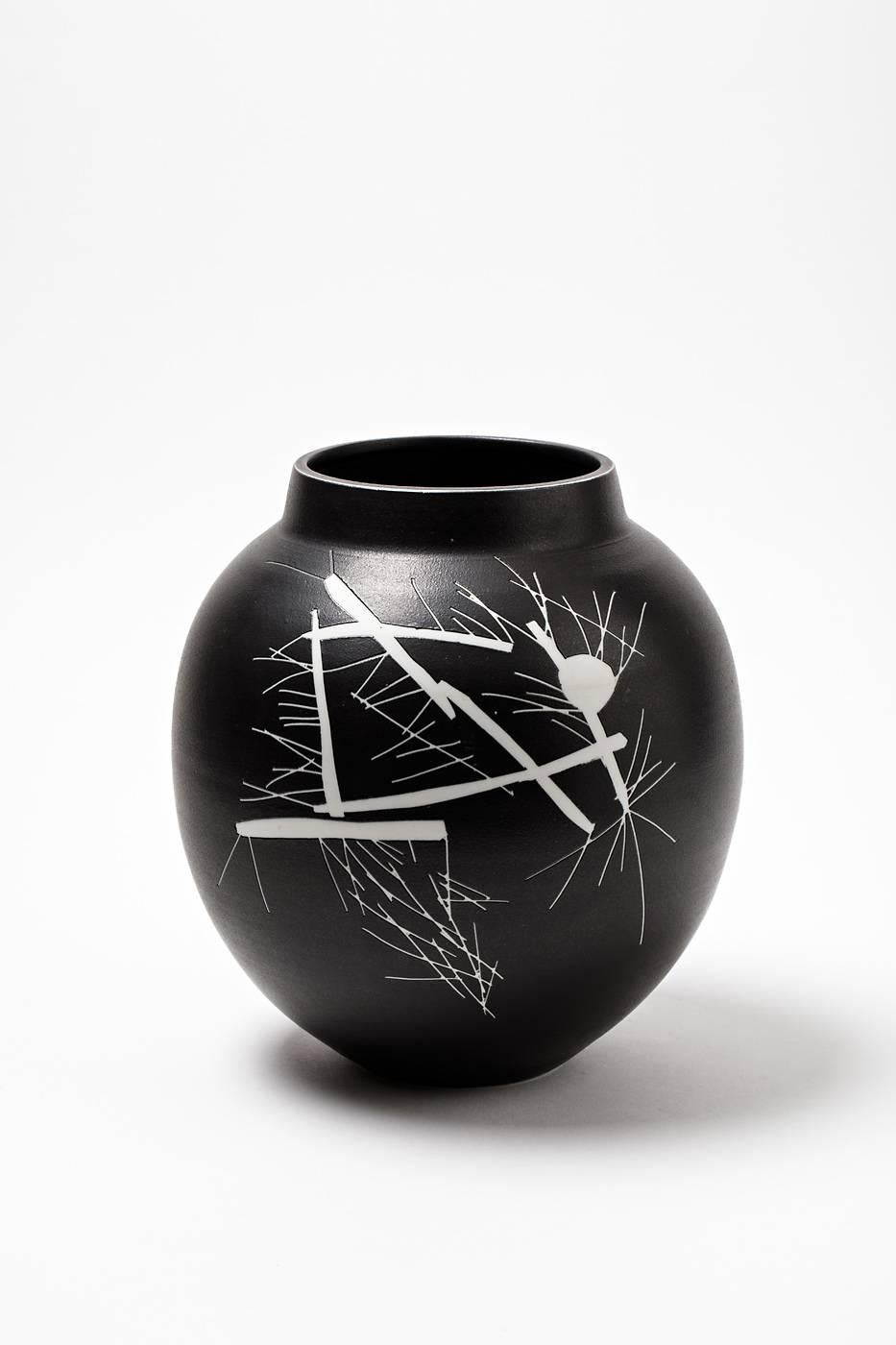 A porcelain vase by Robert Deblander with black glaze and white geometrical decoration.
Handwritten signature under the base and artist monogram, circa 1990.
Unique piece.