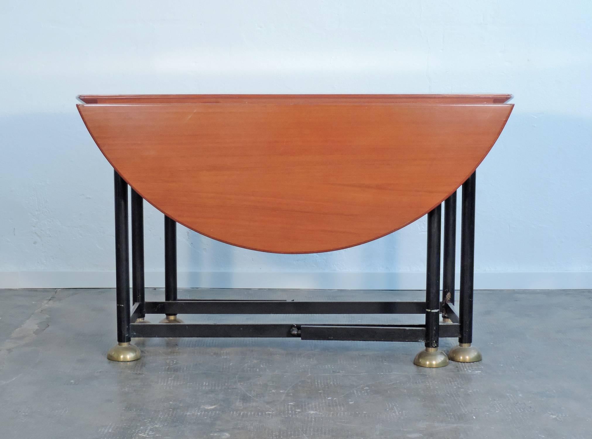 Architectural Italian 20th century folding circular dining table.

Measures: 129.5 x 57.5 cm with wings closed.
